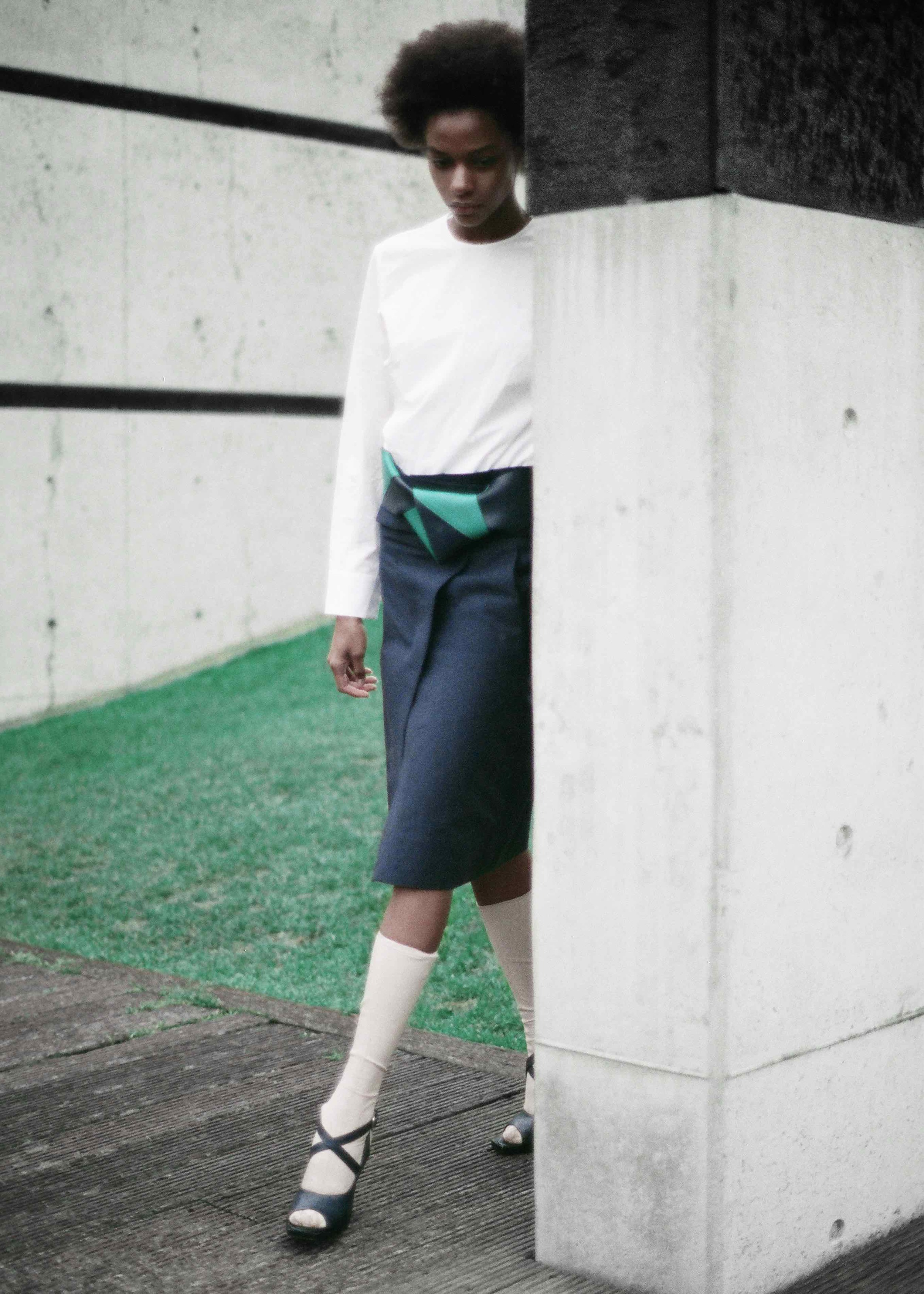  White cotton poplin shirt, cotton gabardine wrap skirt, navy and green leather belt, calf leather socks and sandals.&nbsp; 