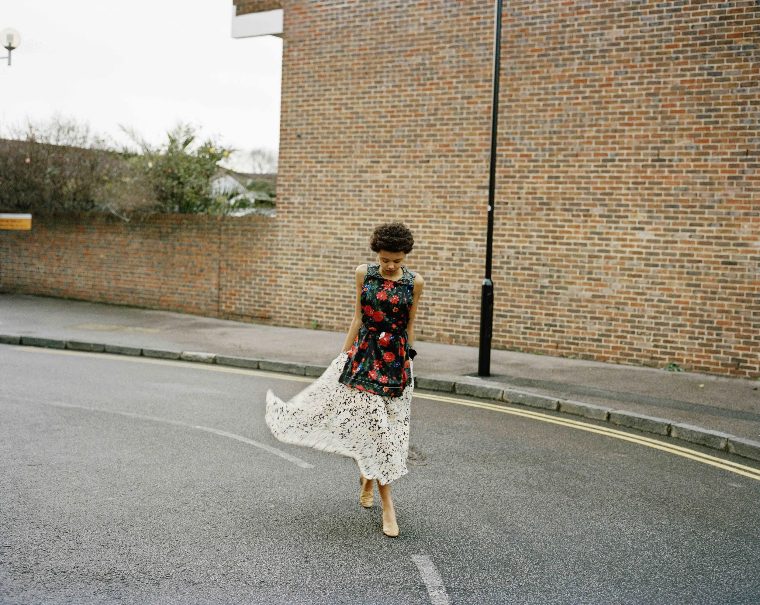 Silk floral printed top and asymmetrical skirt, body hand belt and tan lambskin ballerina pumps.