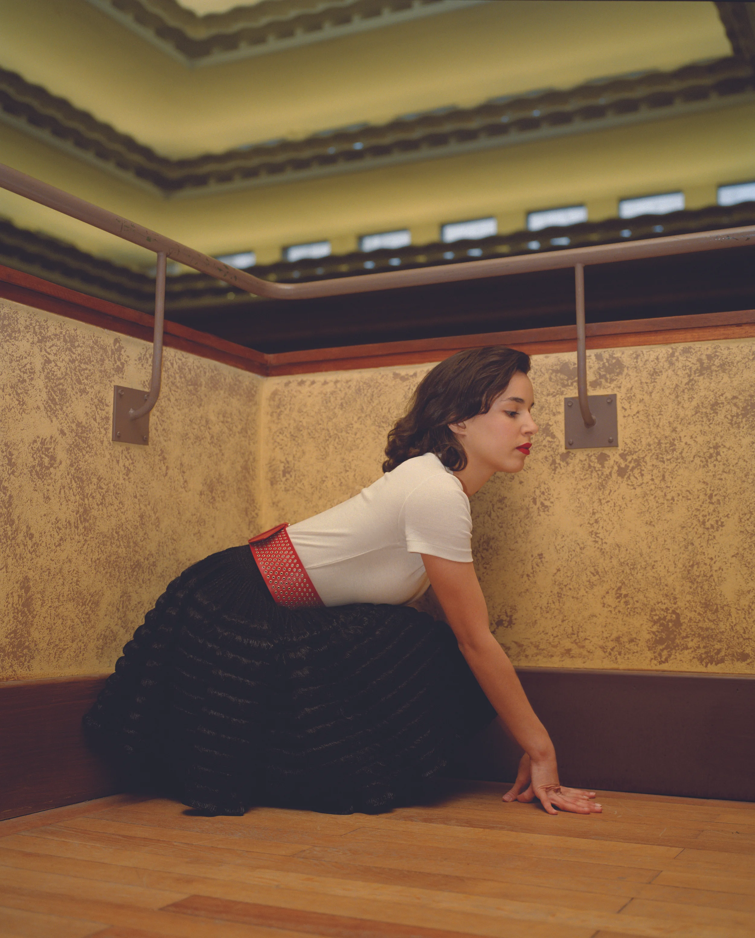 White cotton t-shirt PETIT BATEAU, black skater skirt and red leather belt ALAÏA.
