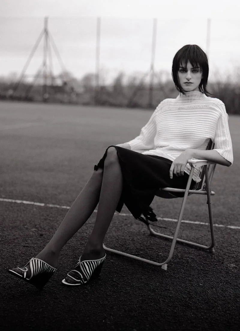 Grill-textured white stretch blouse by ISSEY MIYAKE , black viscose wrap skirt by CALVIN KLEIN COLLECTION , wedge sandals by KENZO , veiled tights stylist's own.