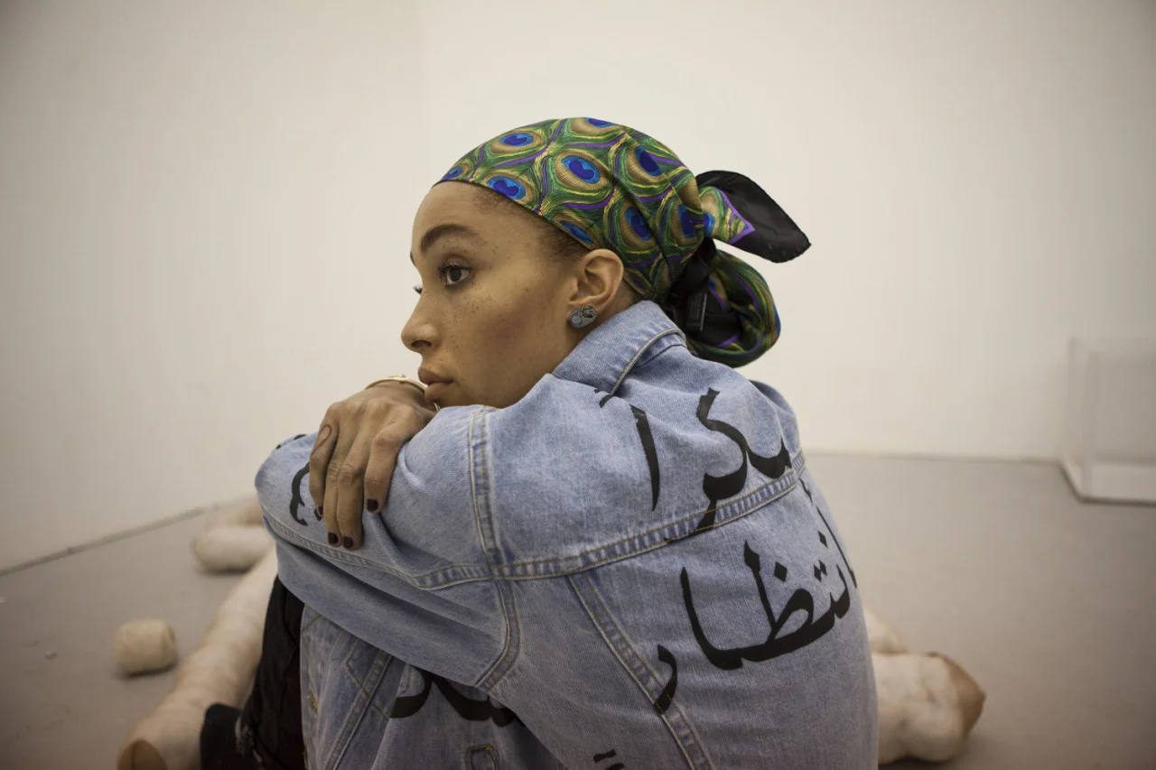 Arabic “Thank you” printed denim jacket ASHISH , embroidered knit top and check embroidered denim trousers LOUIS VUITTON , Swarovski and silver clock earrings MAK JEWELS , cotton socks MARIA LA ROSA .