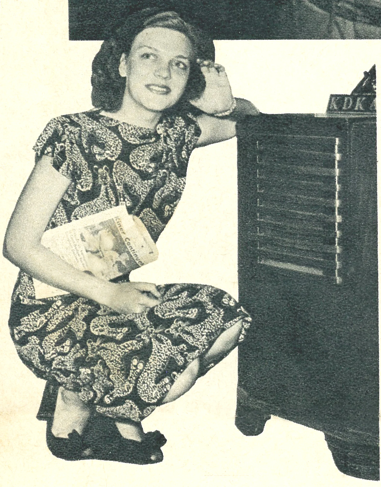 BLO-Kneeling next to radio with sports section.jpg