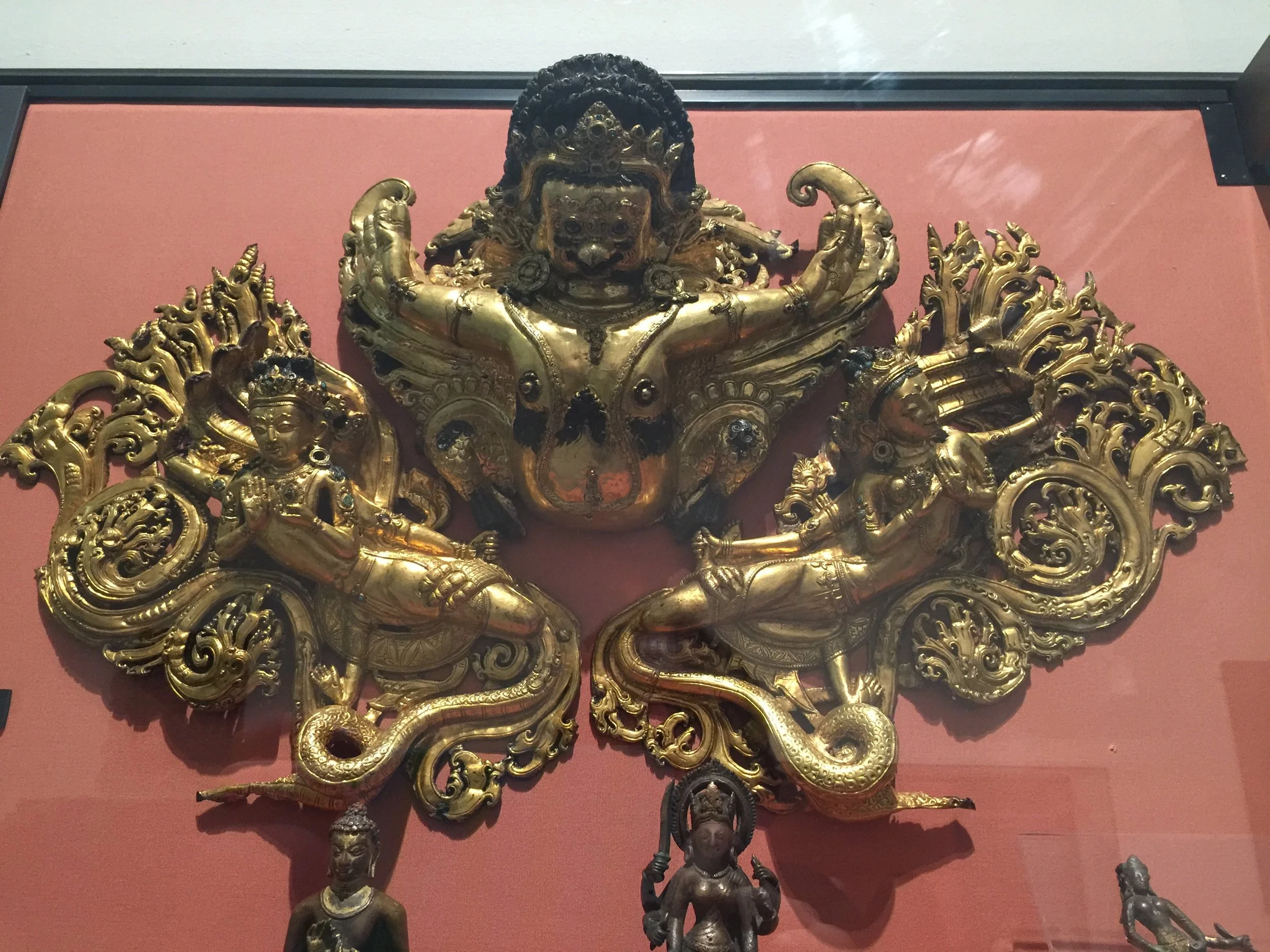 Guruda — the half-human, half-eagle mount of Vishnu — in combat with snake-like water-spirits (nagas), Nepal, 1550-1600. From the Victoria & Albert Museum.