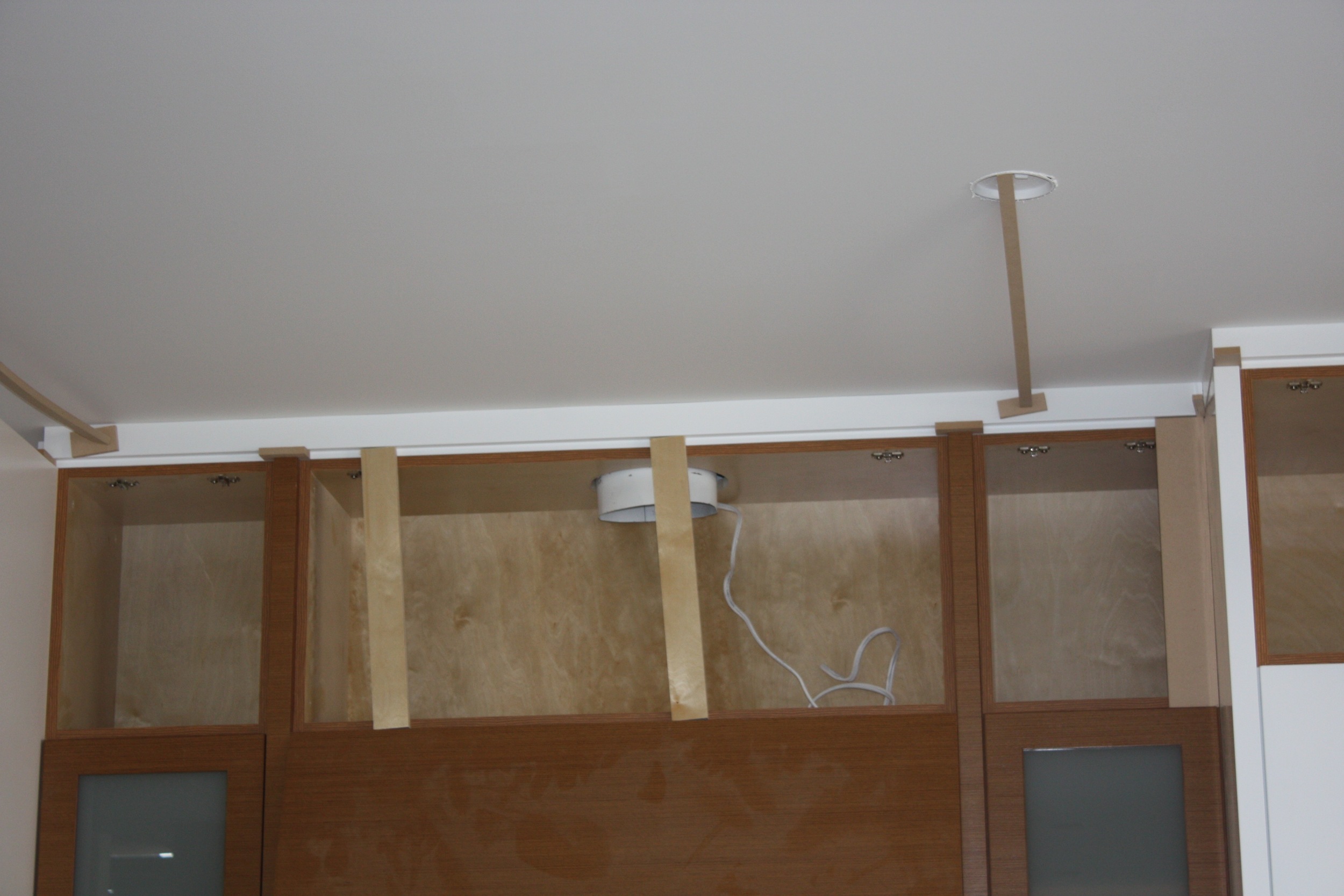 Crown molding installation in the kitchen. Nice to see the recessed lighting has a purpose......