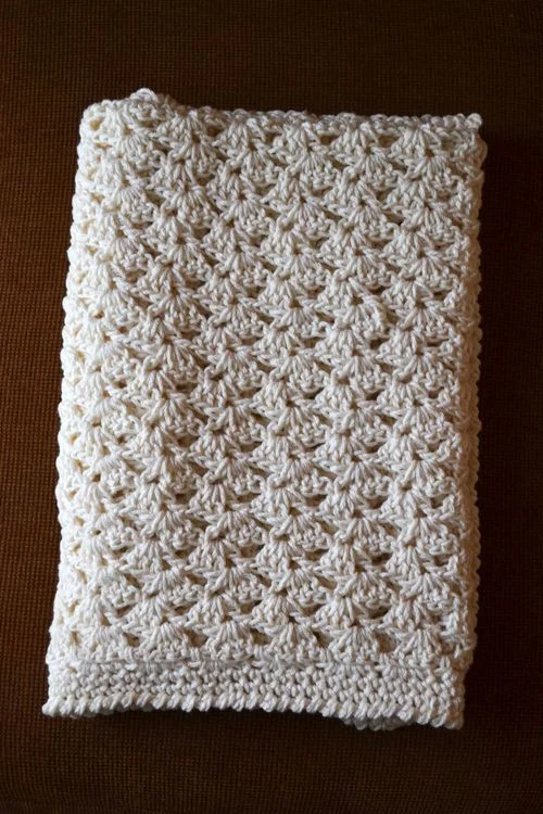 Offset shell stitch baby blanket Started: March 2014 Finished: September 26, 2014 Fiber: Fantasy Naturale, Aran weight 100% cotton Notes: This is one of the first crochet projects that I didn't follow exactly according to the pattern, just kind of improvised based off of the stitch, which was exciting! I based the pattern off of this pattern by Lisa Gutierrez and started it way too big, then started over. I sent it off without the final measurements (doh), but it was definitely a large baby blanket, more like lap size. Total it took about 4 skeins, plus one for the border, which was two rows of single crochet followed by the crab stitch to finish the border. 