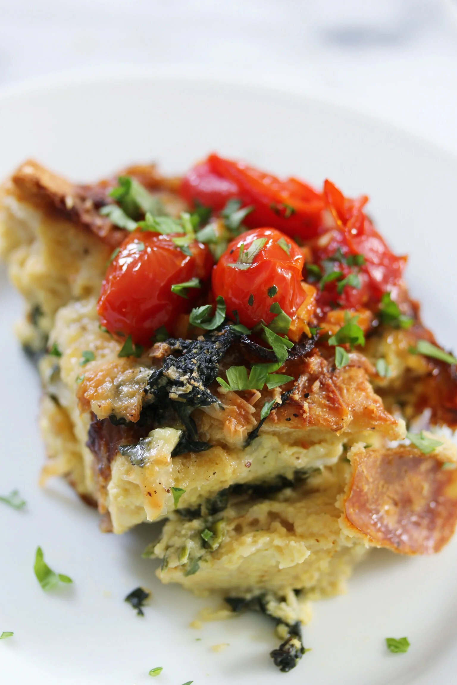 Sausage and spinach egg strata with sautéed cherry tomatoes