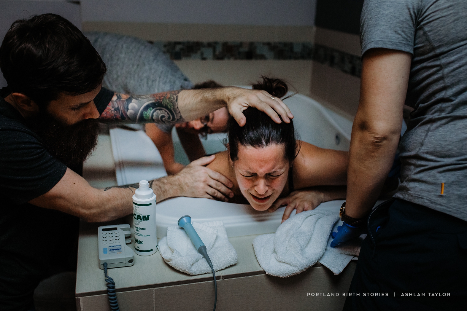 Mother in labor in water tub with midwives