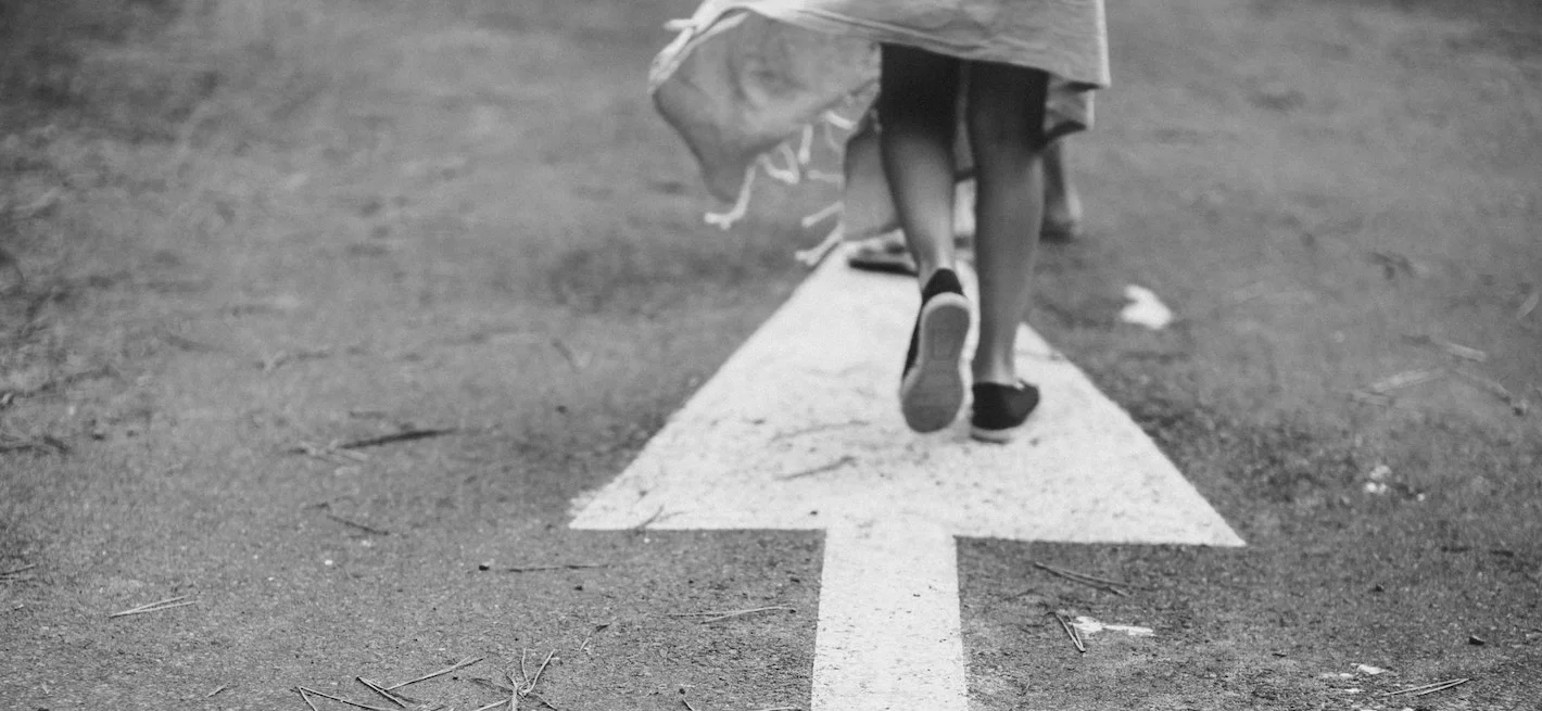 woman-walking-arrow-street-black-white.jpeg