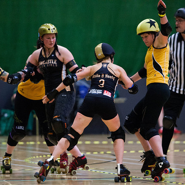 Sarah McMillan skipping up the inside line to avoid a hit from Anita B Nasty; photo courtesy of Dave Moore .