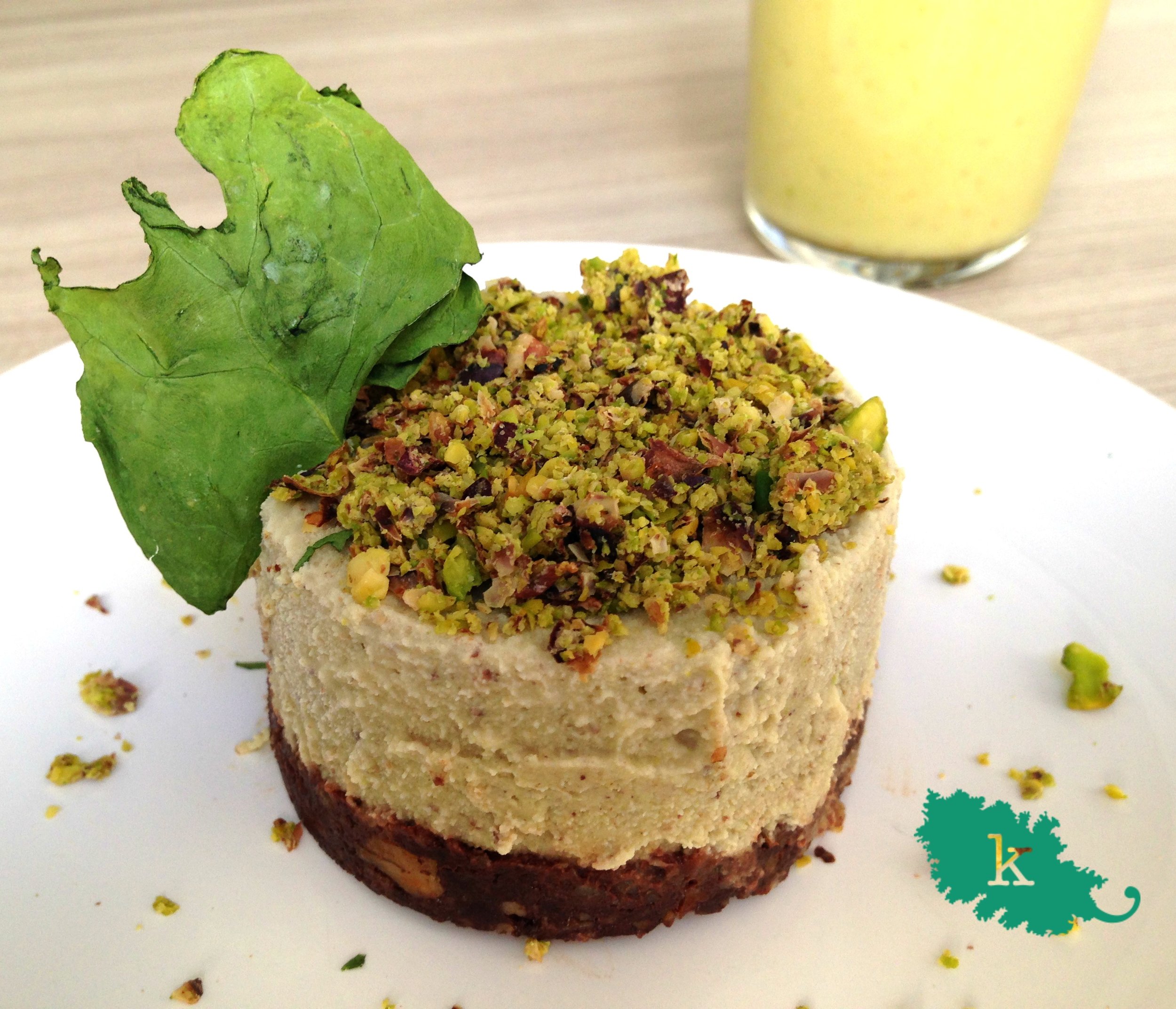 Mantente con el poder del VERDE durante todo el año. ¿Creías que todas las bebidas vegetales son de color blanco. En KALEgría siempre vemos el toque colorido de las cosas. Por eso en la cocina cambiamos el dicho al "Todo es lo que parece" ... Cuando veas un plato colorido, fresco donde todos los ingredientes están entusiasmados los unos con los otros, puedes estar seguro de que SÍ, es lo que parece. La regla es simple: un plato lleno de alimentos frescos te aportara más frescura aún. Y como nos apasionan los ingredientes naturales, os proponemos una "leche" vegetal hecha a base de pistachos. Este fruto seco de color verde intenso que nos recuerda al poder de popeye, contiene una gran cantidad de potasio. Llegando incluso a cubrir el 70% de la CDR. También es rico en magnesio y bajo en sodio. Eso sí, siempre opta por frutos secos de calidad, sin tostar, freír ni sazonar. Los pistachos son unos de los frutos secos que están aliados con el sistema nervioso. Para hacer la bebida de pistachos hemos utilizado el Extractor de Zumos Essenzia de Siquri que además de darnos una pulpa bien seca para poder reciclar se ha lavado en un periquete. BEBIDA DE PISTACHO INGREDIENTES 200 Gr de pistachos 450 Ml de agua filtrada 1 pizca de cardamomo en polvo PREPARACIÓN 1. Mezclar los pistachos con el agua en un bol. 2.. Verter poco a poco el agua y los pistachos con la ayuda de un cacillo en el extractor Essencia de Siquri. El resultado será una exquisita bebida de pistachos. Reservar la pulpa. 3. Echar a la leche la pizca de cardamomo y mezclar. Servir fría o templada según tus preferencias. También puedes endulzar con un dátil o sirope a tu gusto. ...¿ Y CON LA PULPA DE LA LECHE DE PISTACHOS? PASTELITO MORUNO INGREDIENTES PARA UN PASTEL (2 personas) BASE: 50 gr de trigo sarraceno germinado y deshidratado 2 Dátiles CREMA 100 gr de anacardos previamente remojados 100 gr de la pulpa de pistachos resultante de hacer la bebida 2 C. Soperas de sirope de agave 2 C. Soperas de zumo de limón TOPPING Pulpa de la leche de pistachos deshidratada durante 6-12 horas Hojas de menta deshidratadas PREPARACIÓN 1. Triturar el trigo sarraceno. A continuación añadir los dátiles y triturar hasta que quede una masa homogénea. 2. Extender en un molde pequeño. Puede servir un aro de emplatar. 3. Triturar todos los ingredientes de la crema juntos y verter encima de la base. 4. Decorar con el topping de pulpa de pistachos triturados y/o hojas frecas o deshidratas. Como por ejemplo menta. 5. Reservar en la nevera hasta la hora de servir. DI-VERSIONES MORUNAS: Tira por encima del topping una cucharadita de miel ecológica de buena calidad o de agave. ¡¡A disfrutar de este duo postre-merienda!!!