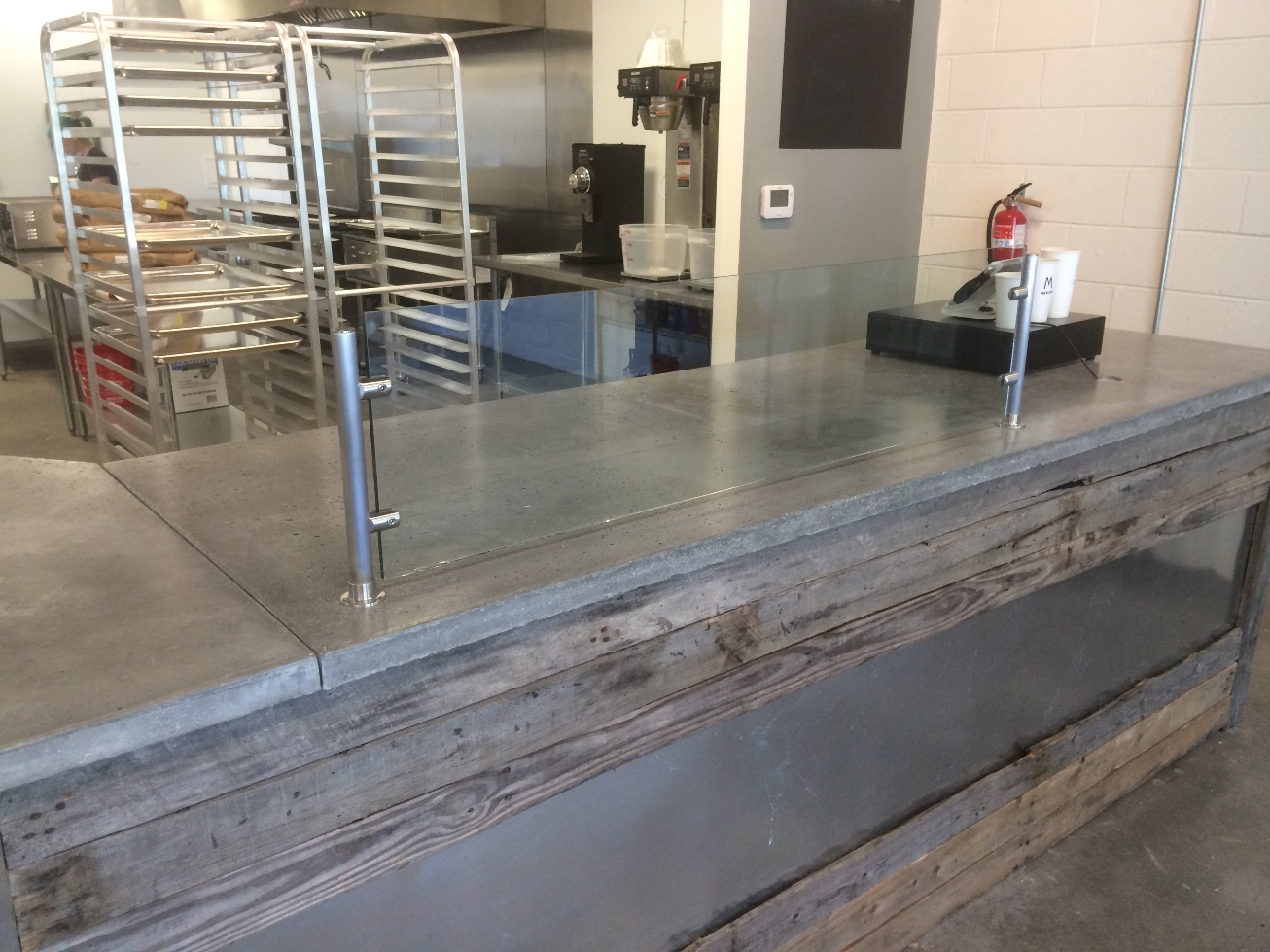 Reclaimed wood and metal wrapped bar with cement countertops.