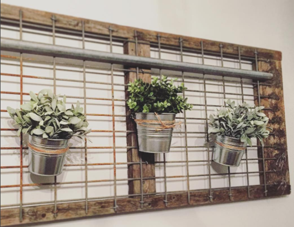 Hung with to wall with wall anchors. Galvanized tins are hung with twine and S hooks. 