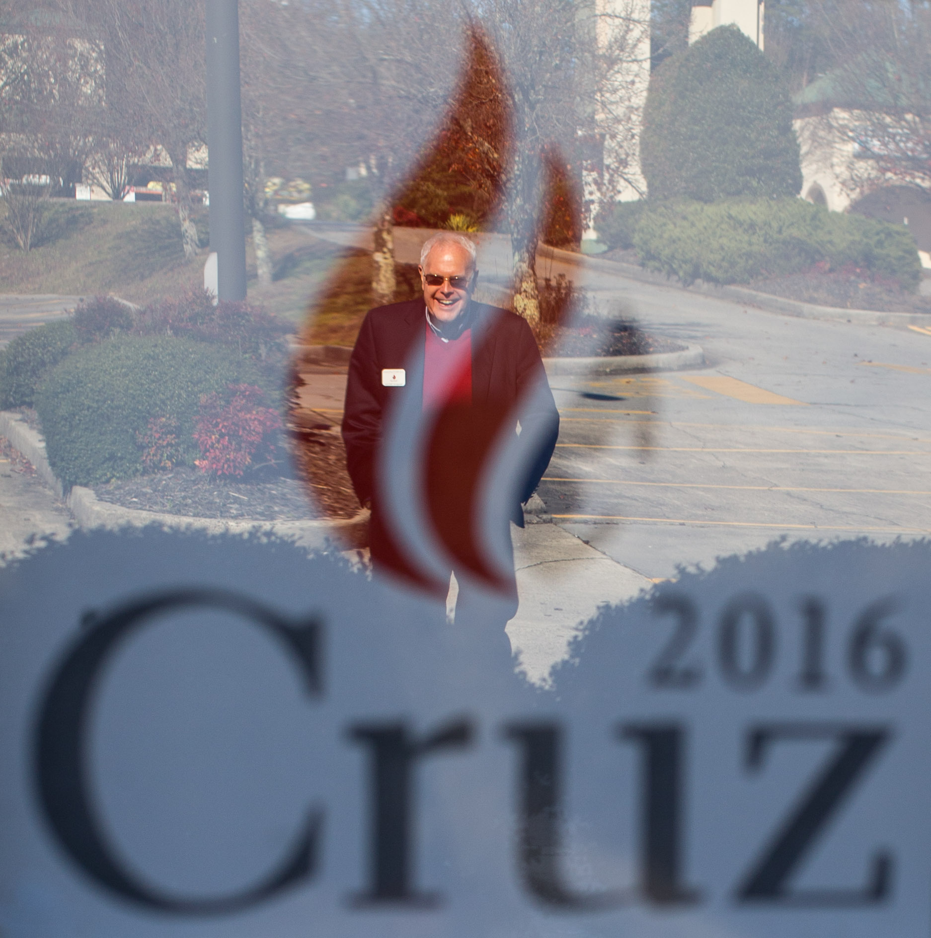 Joe McCutchen is reflected in the window of a local business that is promoting Republican presidential candidate Tex Cruz, Saturday, Dec. 5, 2015, in Ellijay, Ga. 