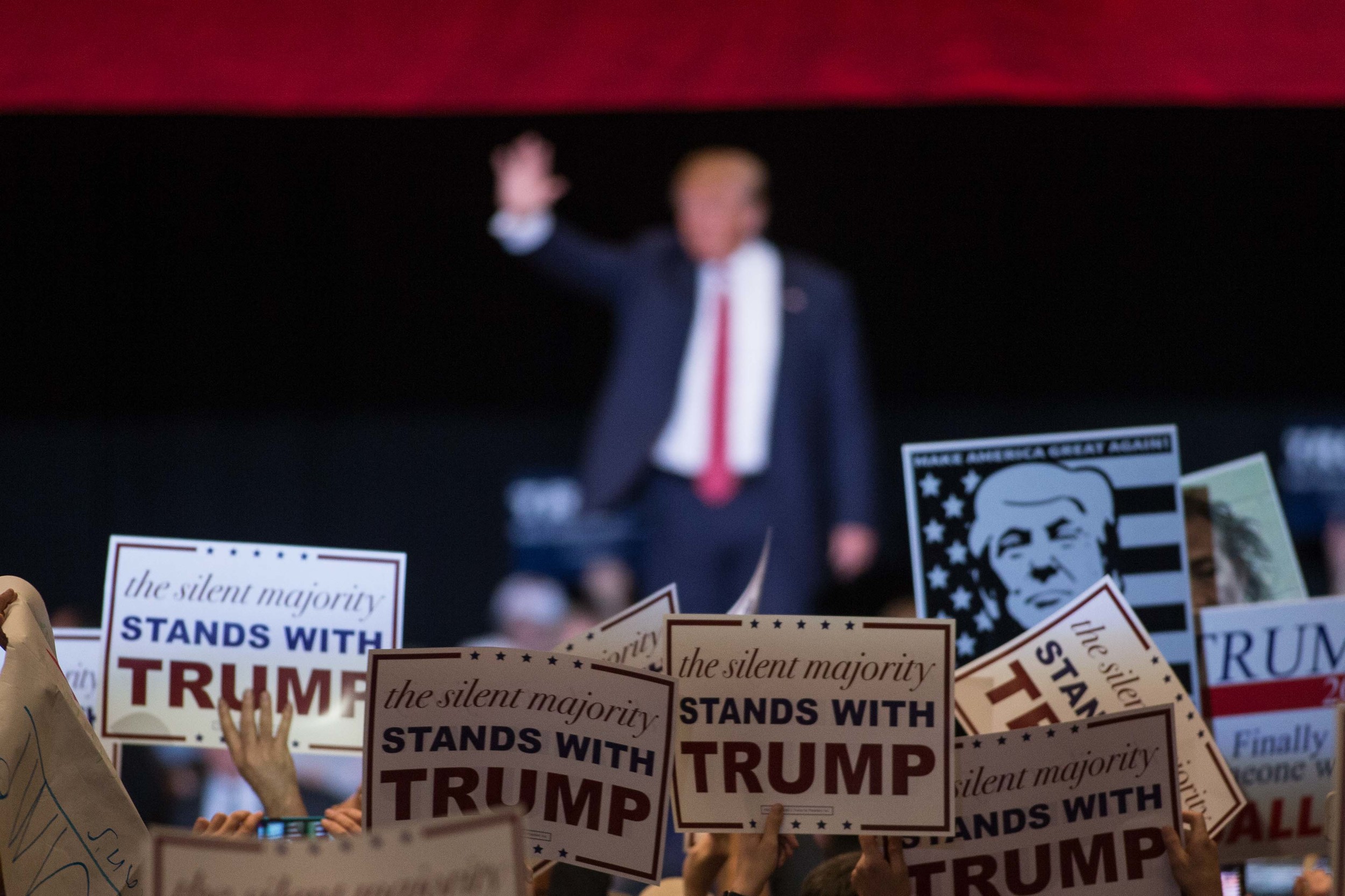 People hold up signs as Republican presidential candidate Donald Trump walks on stage during a campaign rally at the Macon Centreplex, Monday, Nov. 30, 2015, in Macon, Ga. (AP Photo/Branden Camp)