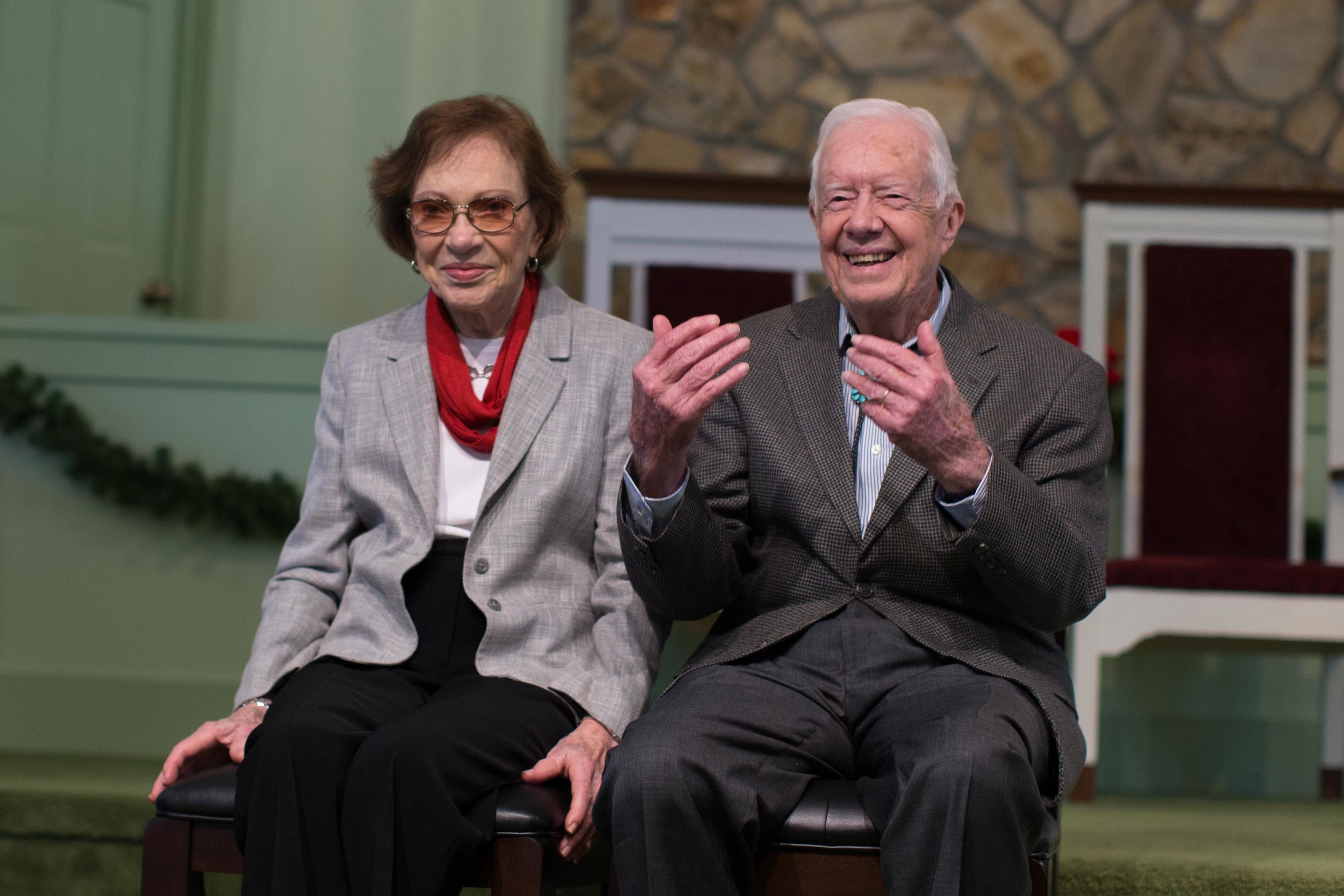 Former President Jimmy Carter, right, sits with his wife, Rosalynn, as they wait to pose for photos with guests at Maranatha Baptist Church, Sunday, Dec. 13, 2015, in Plains, Ga. A recent MRI showing no cancer on Jimmy Carter's brain is "very positive" news for the former president but will not end his medical treatment, doctors said. Carter, 91, announced on Dec. 6 that doctors found no evidence of the four lesions discovered on his brain this summer and no signs of new cancer growth. (AP Photo/Branden Camp)