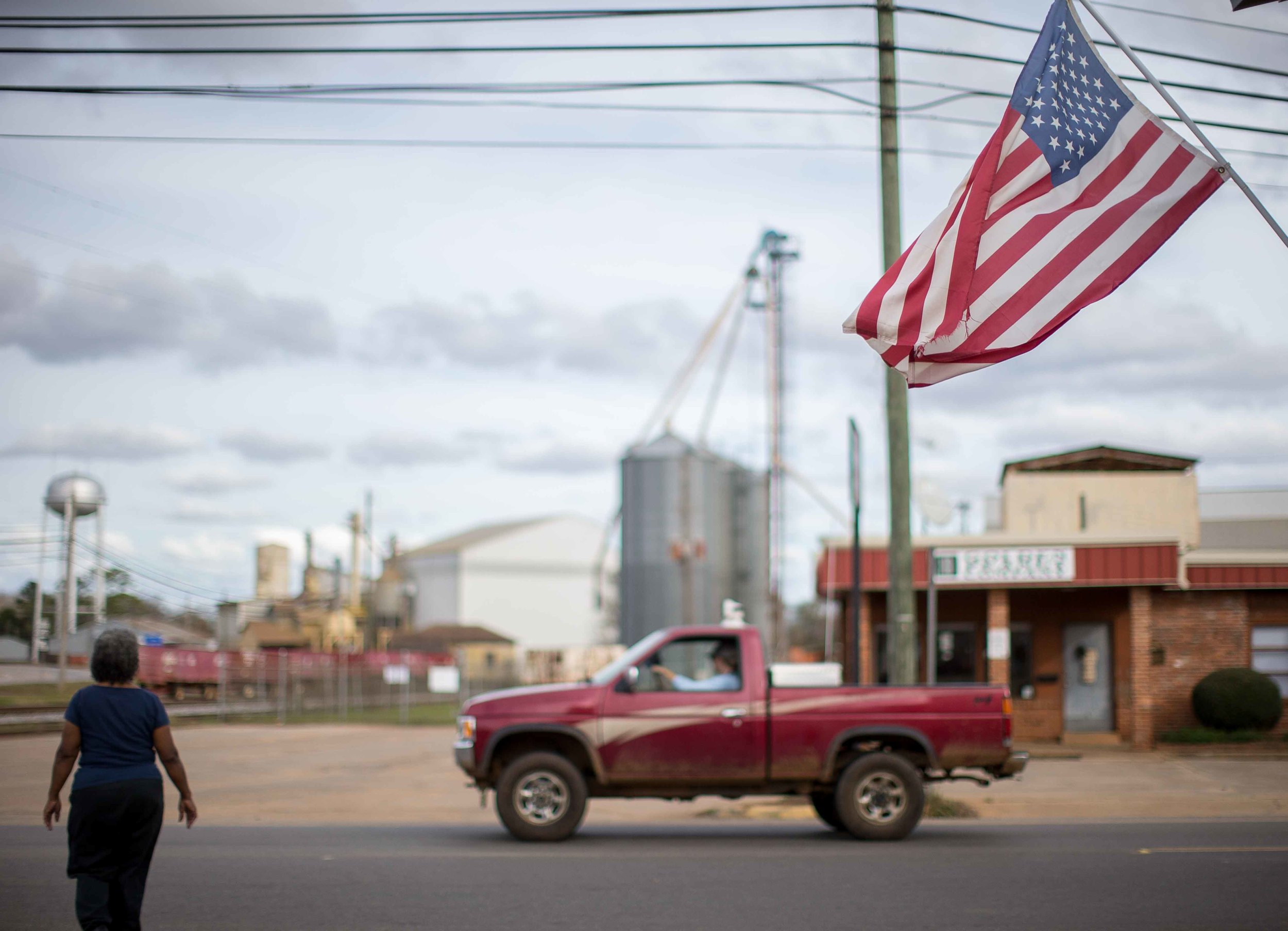 A woman walks through downtown Plains, Ga., Sunday, Dec. 13, 2015. A recent MRI showing no cancer on Jimmy Carter's brain is "very positive" news for the former president but will not end his medical treatment, doctors said. Carter, 91, announced Dec. 6 that doctors found no evidence of the four lesions discovered on his brain this summer and no signs of new cancer growth. (AP Photo/Branden Camp)