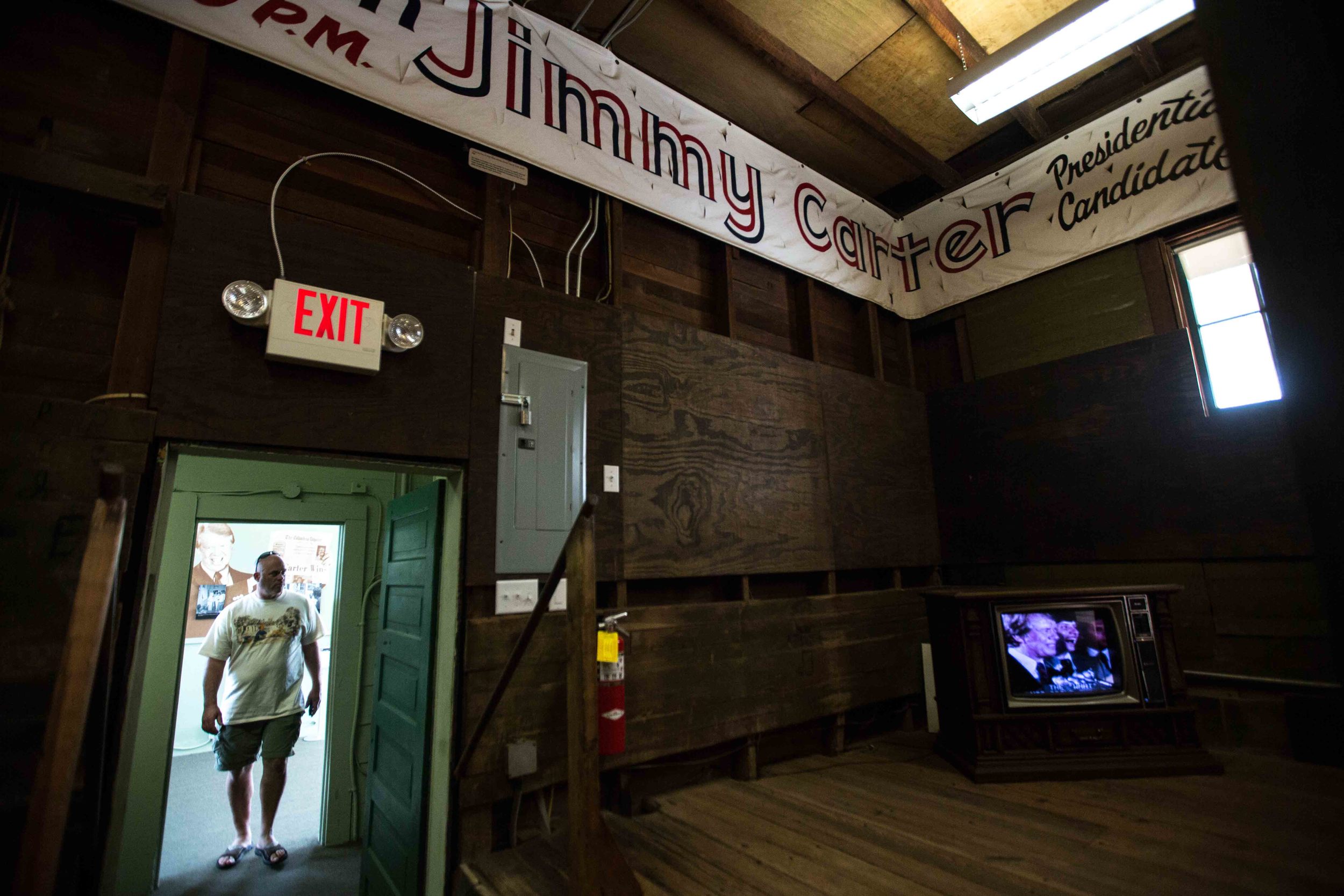 A man walks through former President Jimmy Carters' campaign headquarters in downtown Plains, Ga., Sunday, Dec. 13, 2015. A recent MRI showing no cancer on Jimmy Carter's brain is "very positive" news for the former president but will not end his medical treatment, doctors said. Carter, 91, announced Dec. 6 that doctors found no evidence of the four lesions discovered on his brain this summer and no signs of new cancer growth. (AP Photo/Branden Camp)