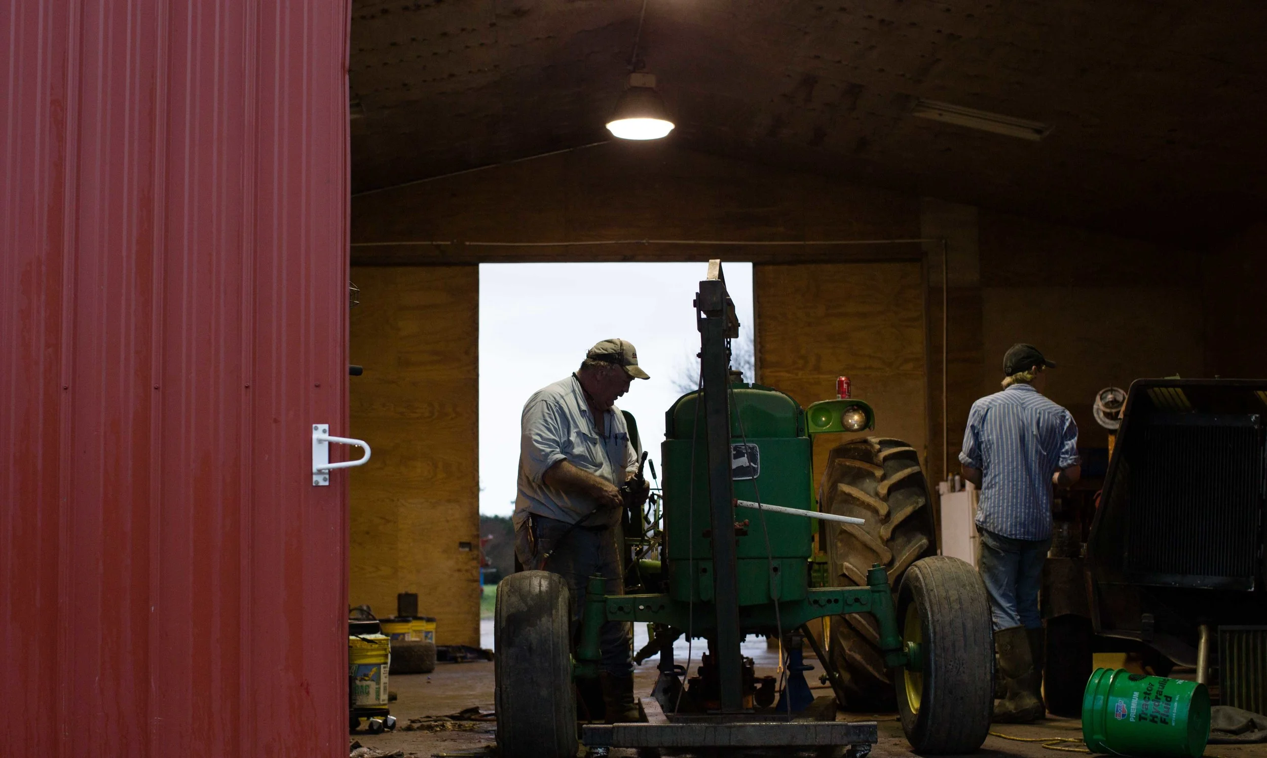 Farmer Phil Sanders, left, and Chance Fowler, 20, right, work on a John Deere tractor at Buffalo Creek Straw and Seed Farm, Wednesday, Feb. 3, 2016, in Stephens, Ga. With over 42,000 farmers working in the Georgia agriculture industry, farming contributes over $73 Billion to Georgia’s economy each year. Forecasters say profits are expected be down as well as exports in 2016 nationwide due to a fragile world economy. Photo by Branden Camp