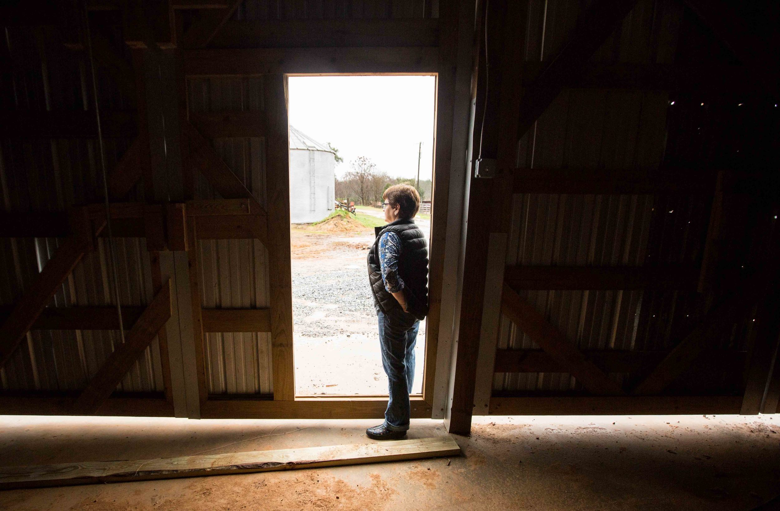 Farmer Melanie Sanders stands in the door a storage building on Buffalo Creek Straw and Seed Farm, Wednesday, Feb. 3, 2016, in Stephens, Ga. With over 42,000 farmers working in the Georgia agriculture industry, farming contributes over $73 Billion to Georgia’s economy each year. Forecasters say profits are expected be down as well as exports in 2016 nationwide due to a fragile world economy. Photo by Branden Camp