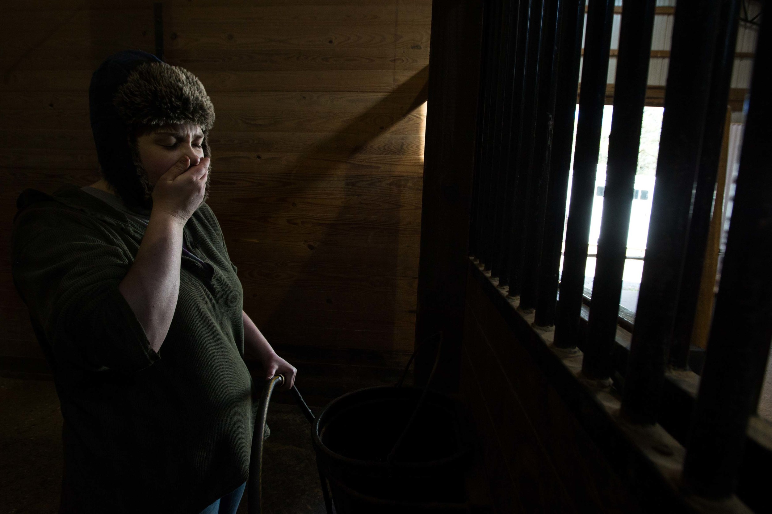 Rebecca Thompson yawns while she works inside a horse stable on a cold day, Wednesday, Feb. 10, 2016, in Woodstock, Ga. (AP Photo/Branden Camp)