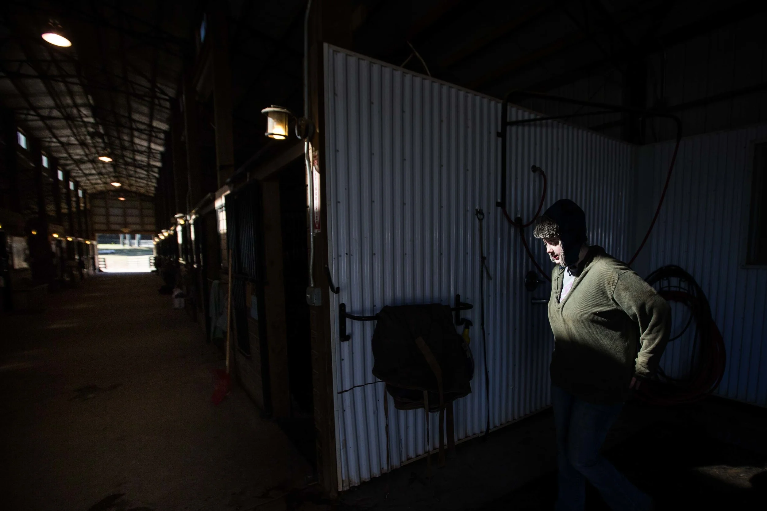 Rebecca Thompson works inside a horse stable on a cold day, Wednesday, Feb. 10, 2016, in Woodstock, Ga. (AP Photo/Branden Camp)