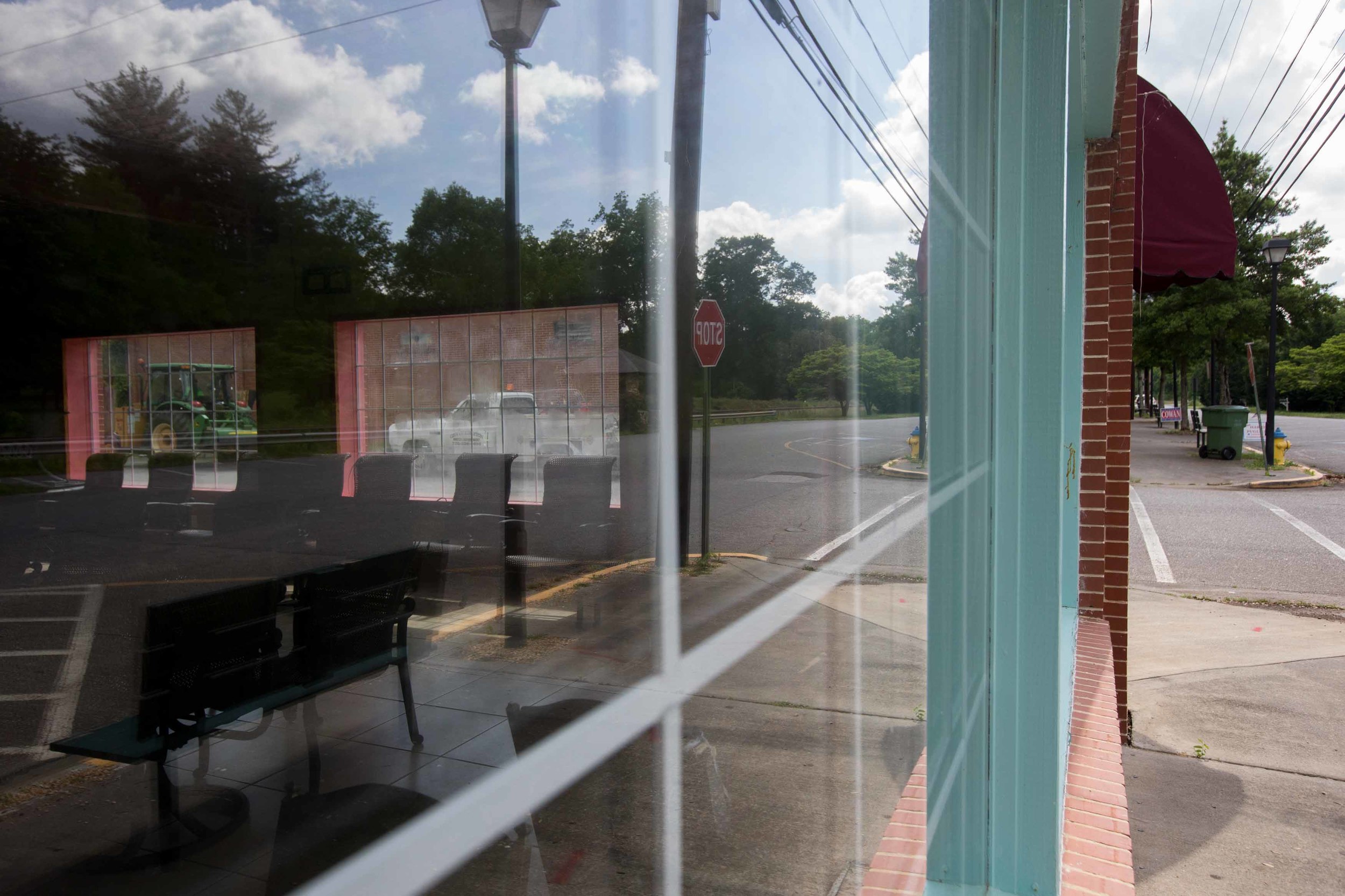  A tractor and a utility truck are seen through the windows what used to be a restaurant in downtown Kingston, Ga. 