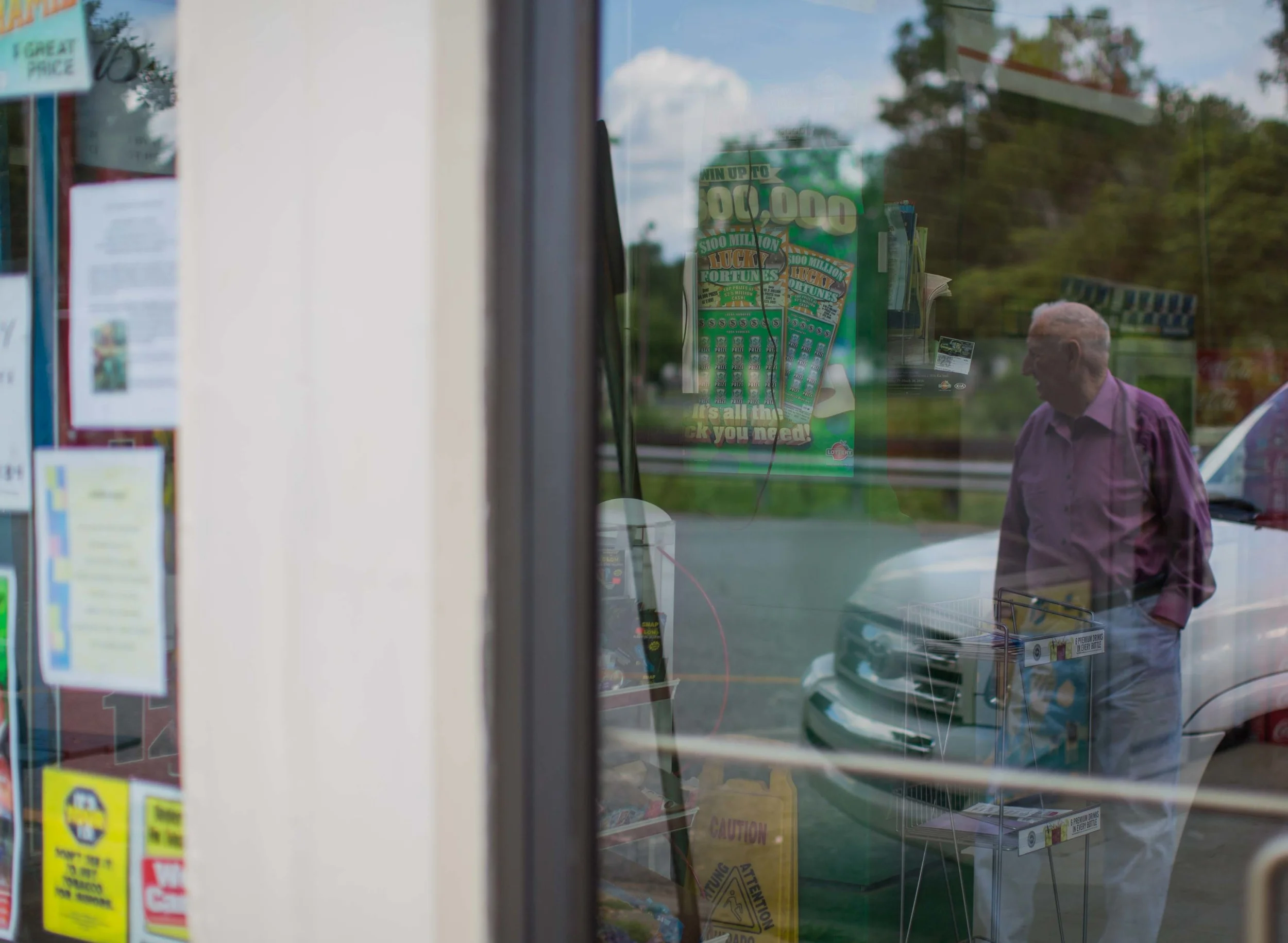 86-year-old G.B. Hood, who has lived in Kingston his whole life, is reflected in the doors of a local convenience store in downtown Kingston, Ga.