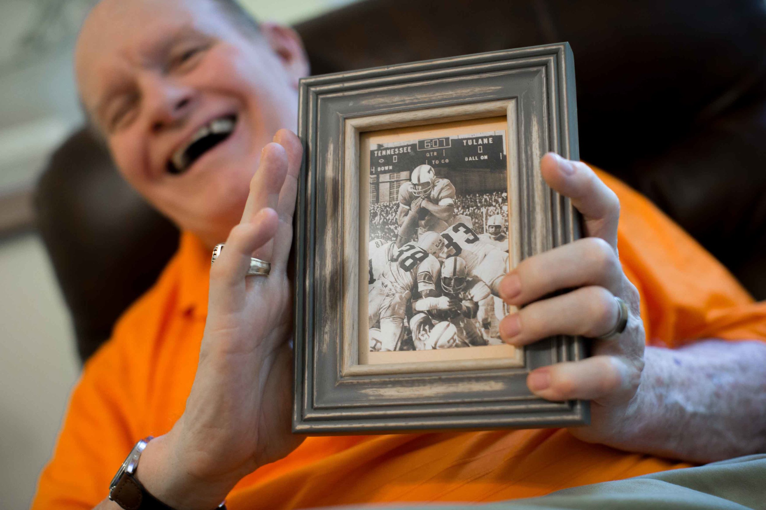 Walter Chadwick, who was a star running back at the University of Tennessee, poses for a portrait at his home while holding a photo of him scoring a touchdown during a game against Tulane University, Sunday, Aug. 28, 2016, in Decatur, Ga. Chadwick was named head coach of Wills High School in 1971, but after only being on the job just two weeks, a Wells Fargo armored van slammed into him leaving Chadwick permanently brain damaged. Chadwick recently gathered with friends and former students, many of whom thought he was dead. (Branden Camp for The Atlanta-Journal Constitution)