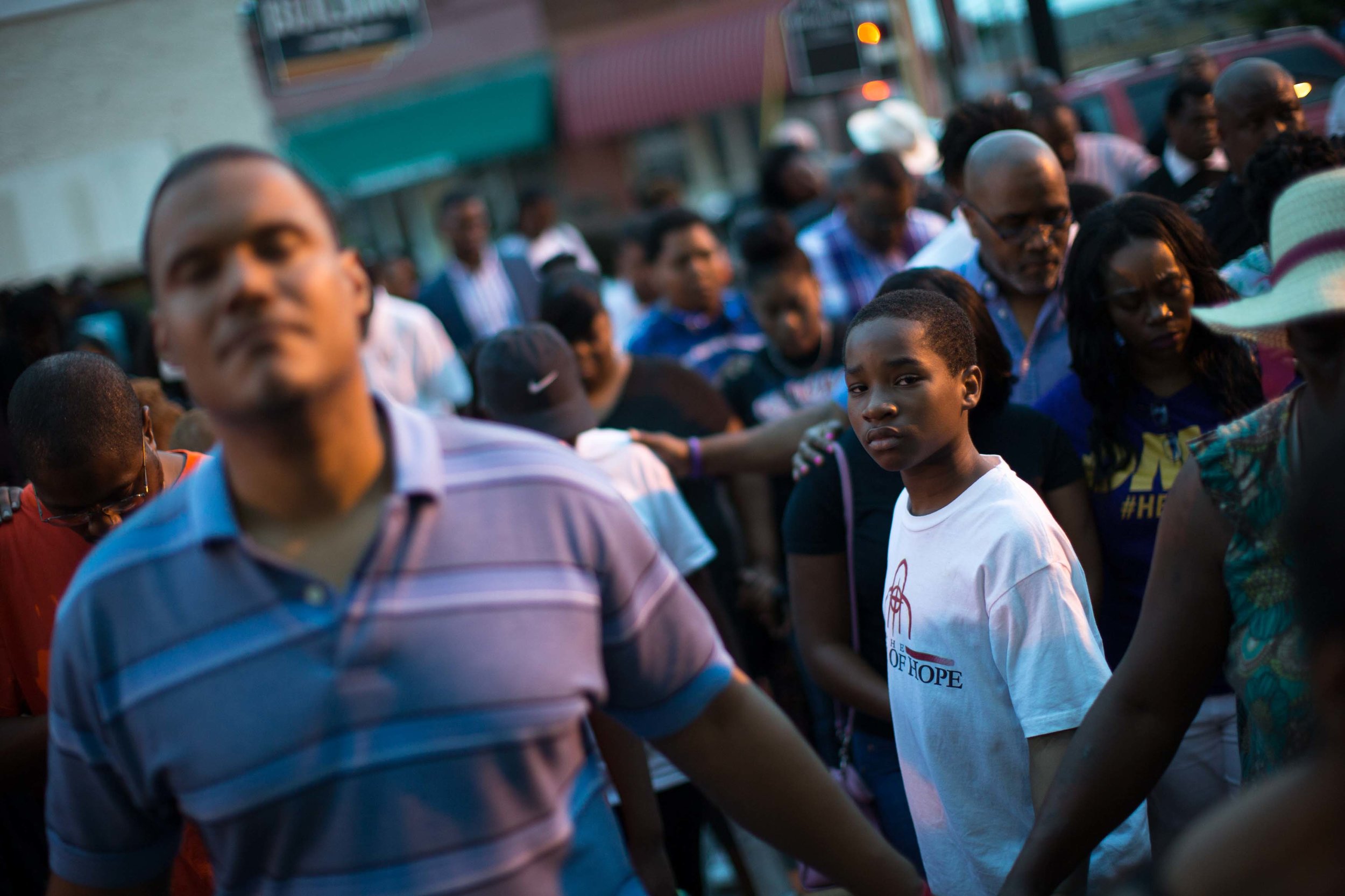 Marty Price, 11, attends a Black Lives Matter prayer vigil on the steps of the First Baptist Church, a predominantly African-American congregation, in Macon, Ga., on Monday, July 11, 2016. The pastors of both First Baptist Churches in Macon are trying to bridge the stubborn divide of race against a painful and tumultuous backdrop: the 2015 massacre at a historic black church in Charleston, South Carolina; the much-publicized deaths of blacks at the hands of law enforcement; the rise of the Black Lives Matter movement, and the sniper killing of white Dallas police officers. (AP Photo/Branden Camp)
