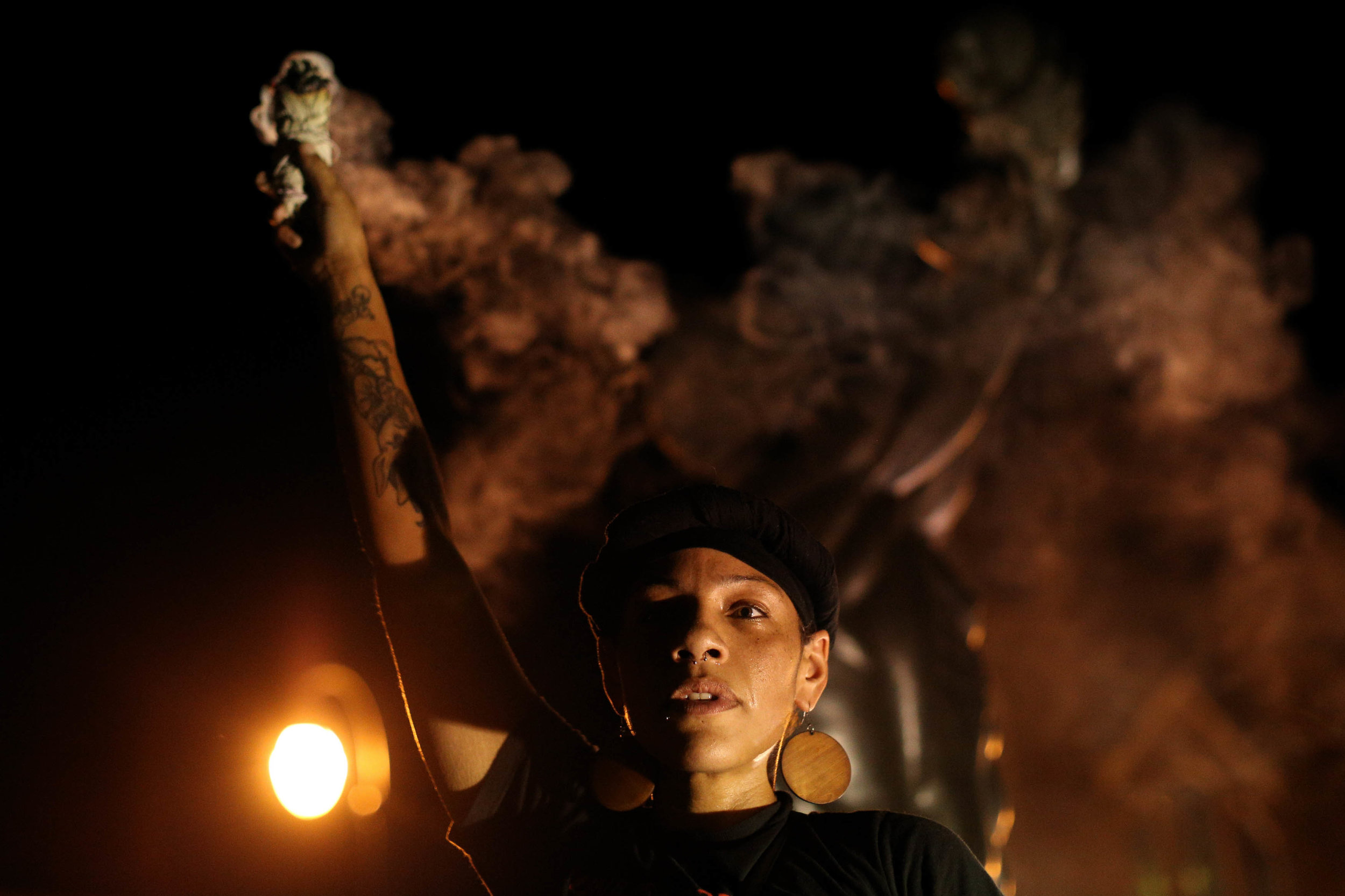 A demonstrator burns sage at the Martin Luther King Jr. Historical Site during a protest in Atlanta on Friday, Sept. 23, 2016 in response to the police shooting deaths of Terence Crutcher in Tulsa, Okla. and Keith Lamont Scott in Charlotte, N.C. (AP Photo/Branden Camp)