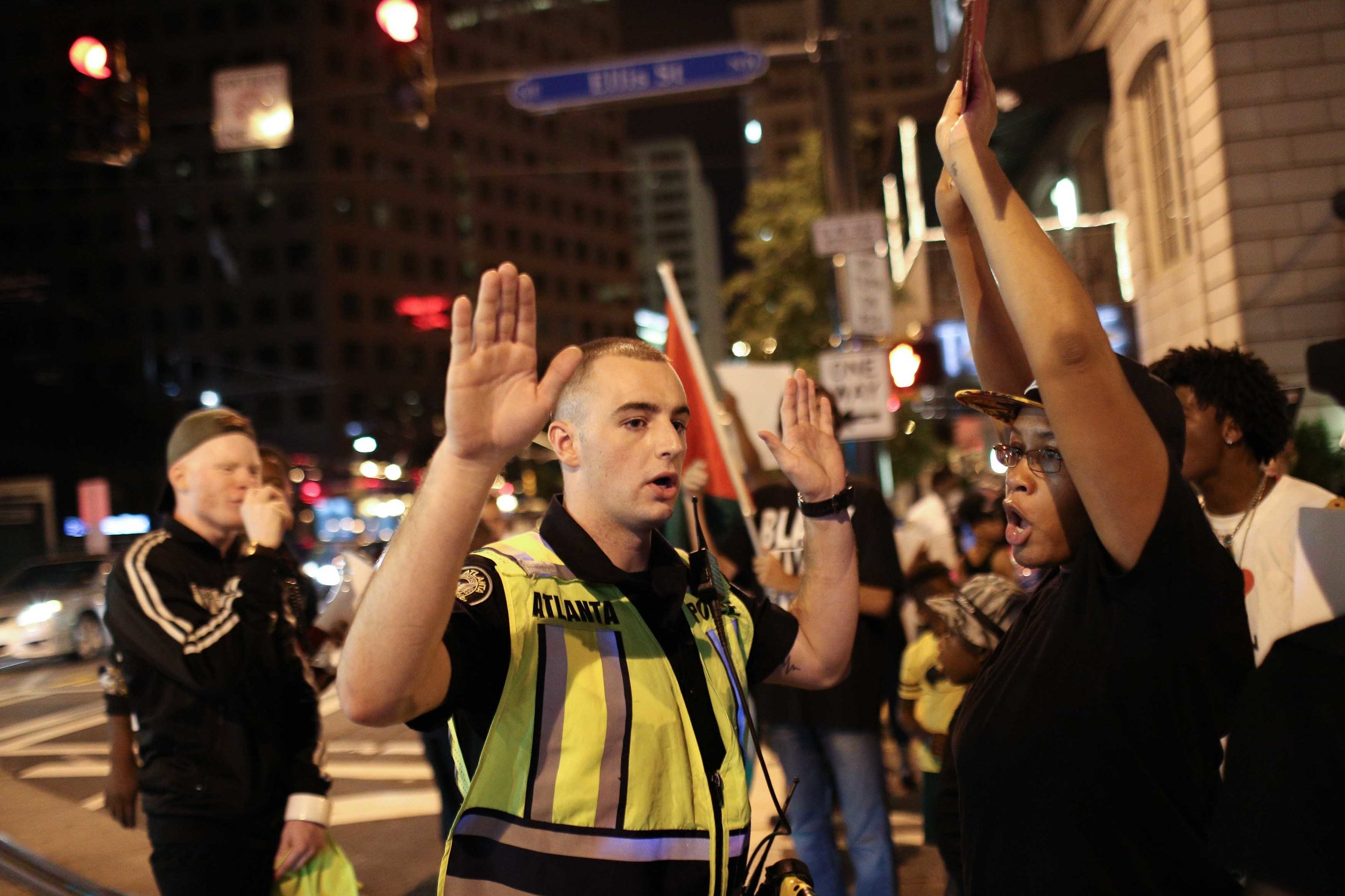 An Atlanta police officer tells Black Lives Matter protesters to move out of the street during a protest in downtown Atlanta, Saturday, Sept. 24, 2016. The protesters gathered in response to the police shooting deaths of Terence Crutcher in Tulsa, Okla. and Keith Lamont Scott in Charlotte, N.C. (AP Photo/Branden Camp)