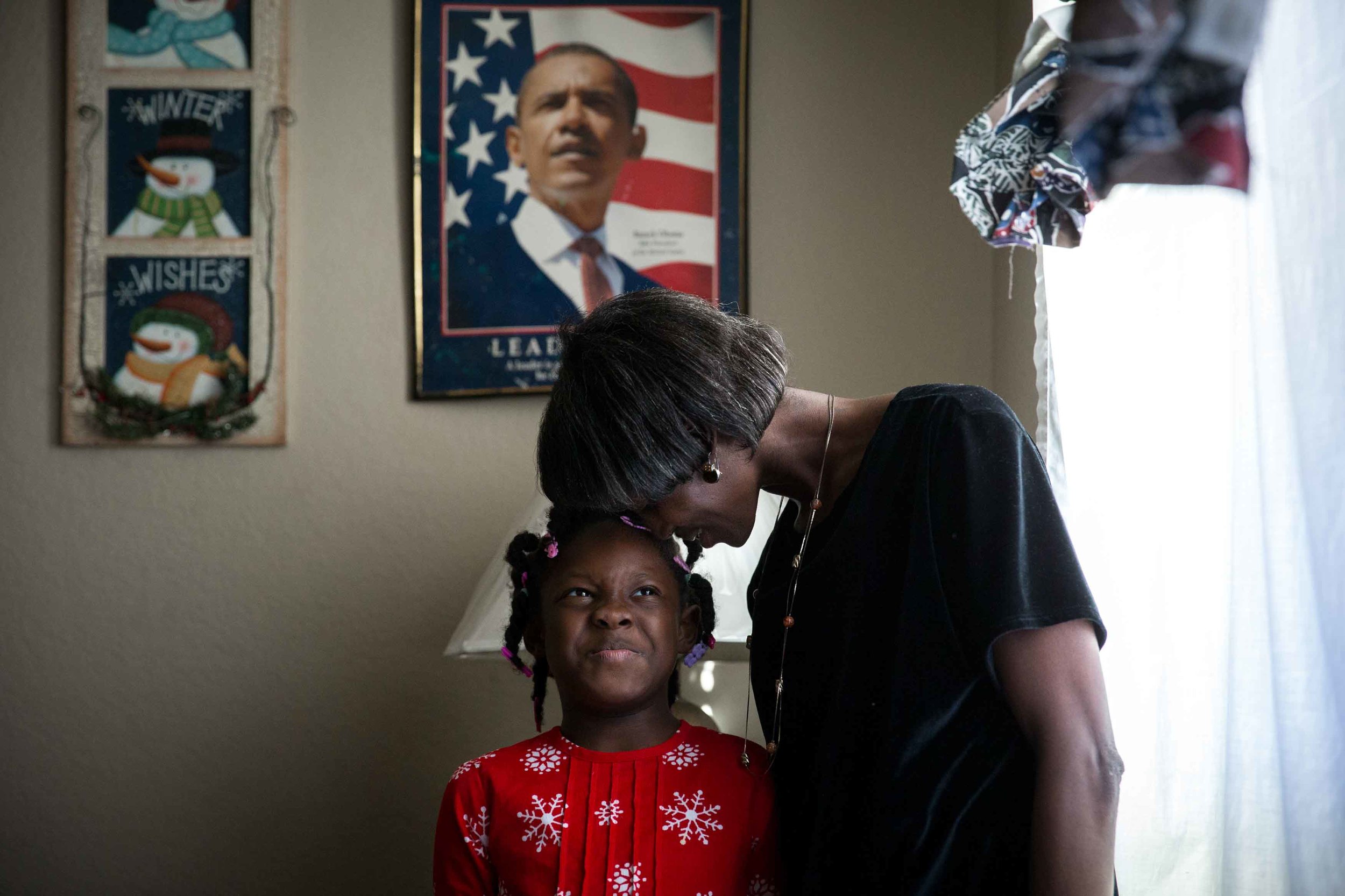 Cherry Glover, who has a developmental disability, lays her head on her daughter, Asia Glover, 7, in hopes of getting her to smile at their Atlanta home as they pose for a portrait. Glover and her four kids are one of more than 100 families in metro Atlanta that will be helped by All About Developmental Disabilities’ Adopt-a-Family program this year. Branden Camp for The Atlanta Journal-Constitution