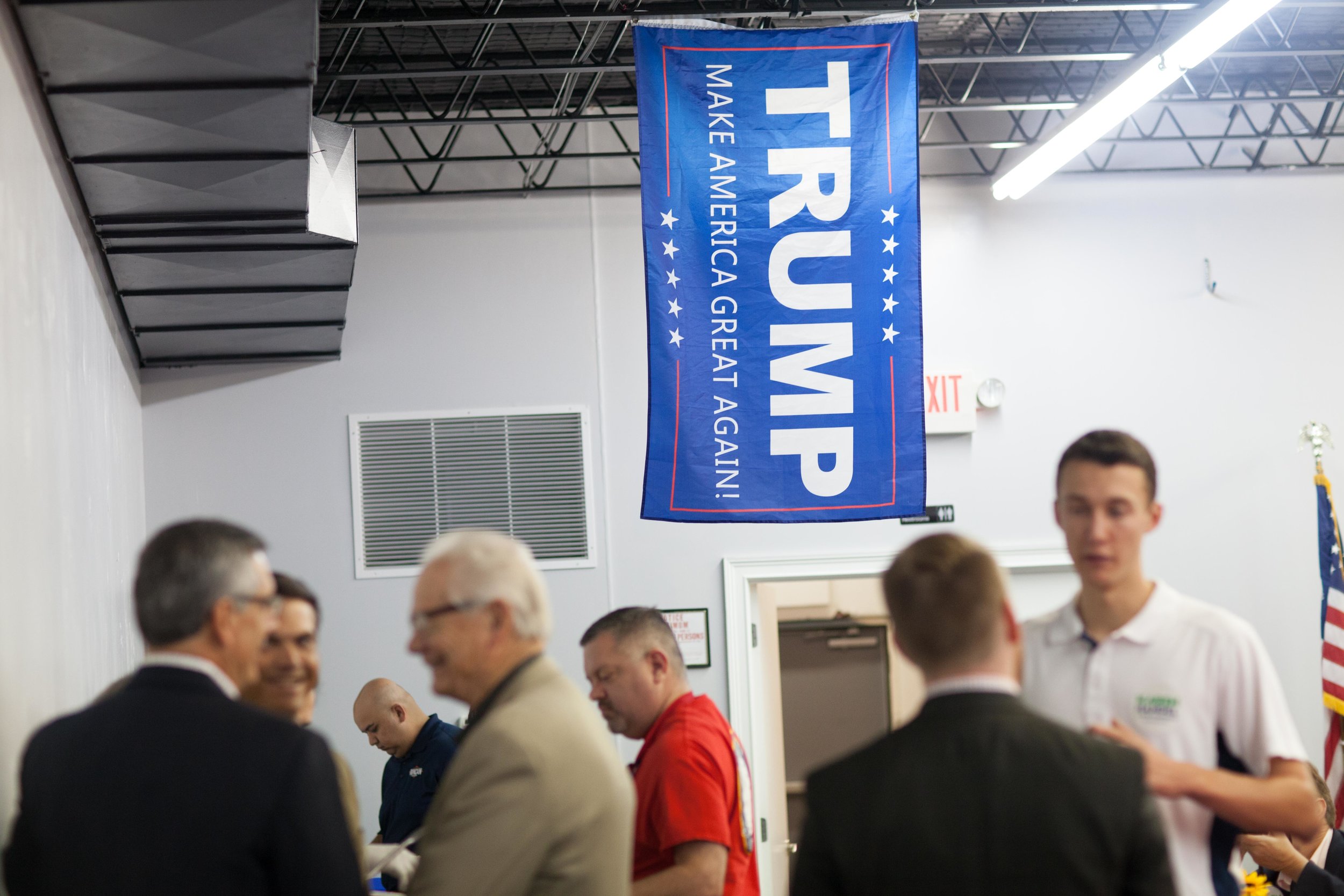 A Trump flag hangs from the ceiling as people talk during a breakfast meet and greet at the Cobb County GOP headquarters, Saturday, Oct.6, 2018, in Marietta, Ga.