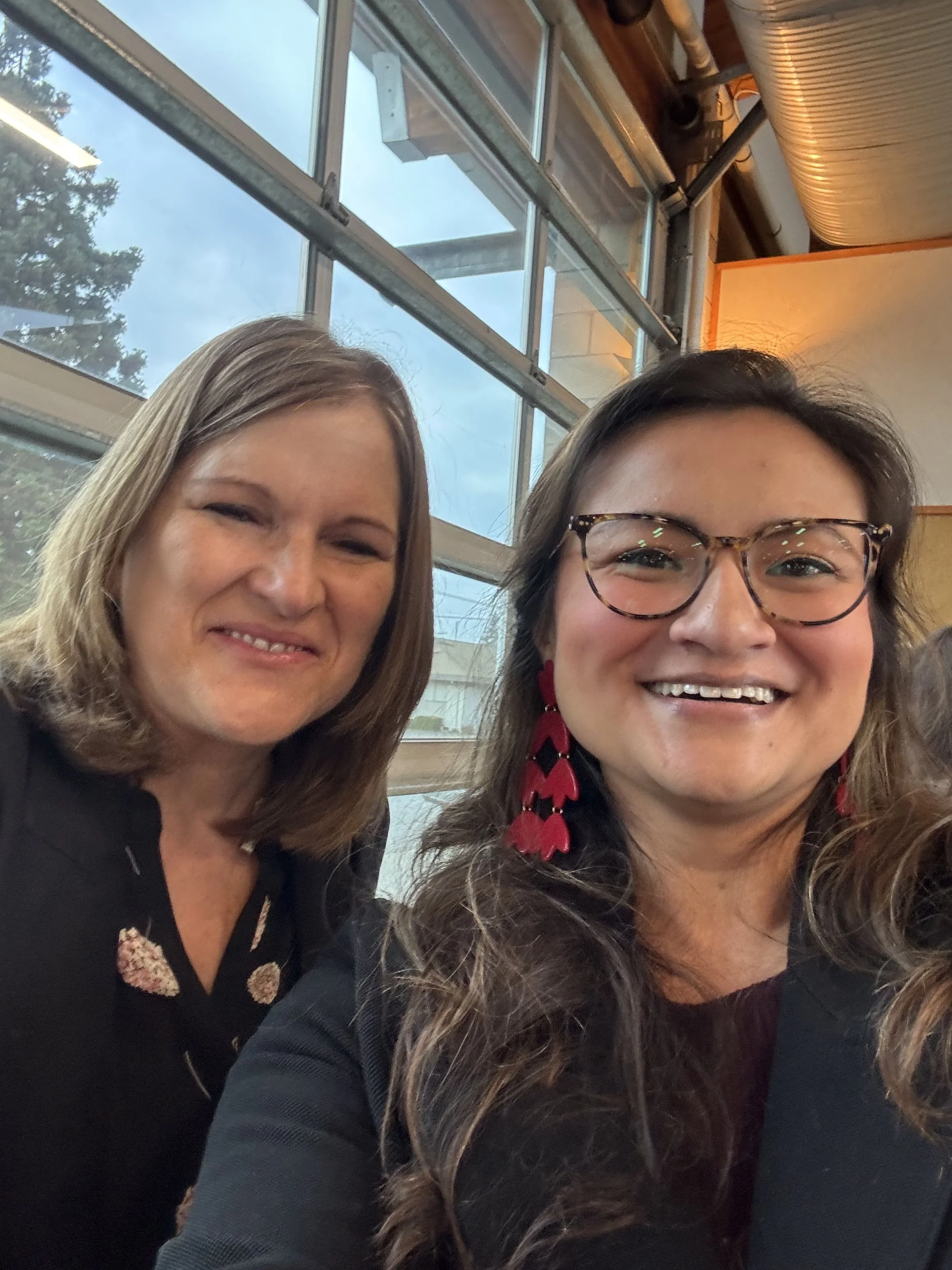 Two women smiling together for a selfie at the event