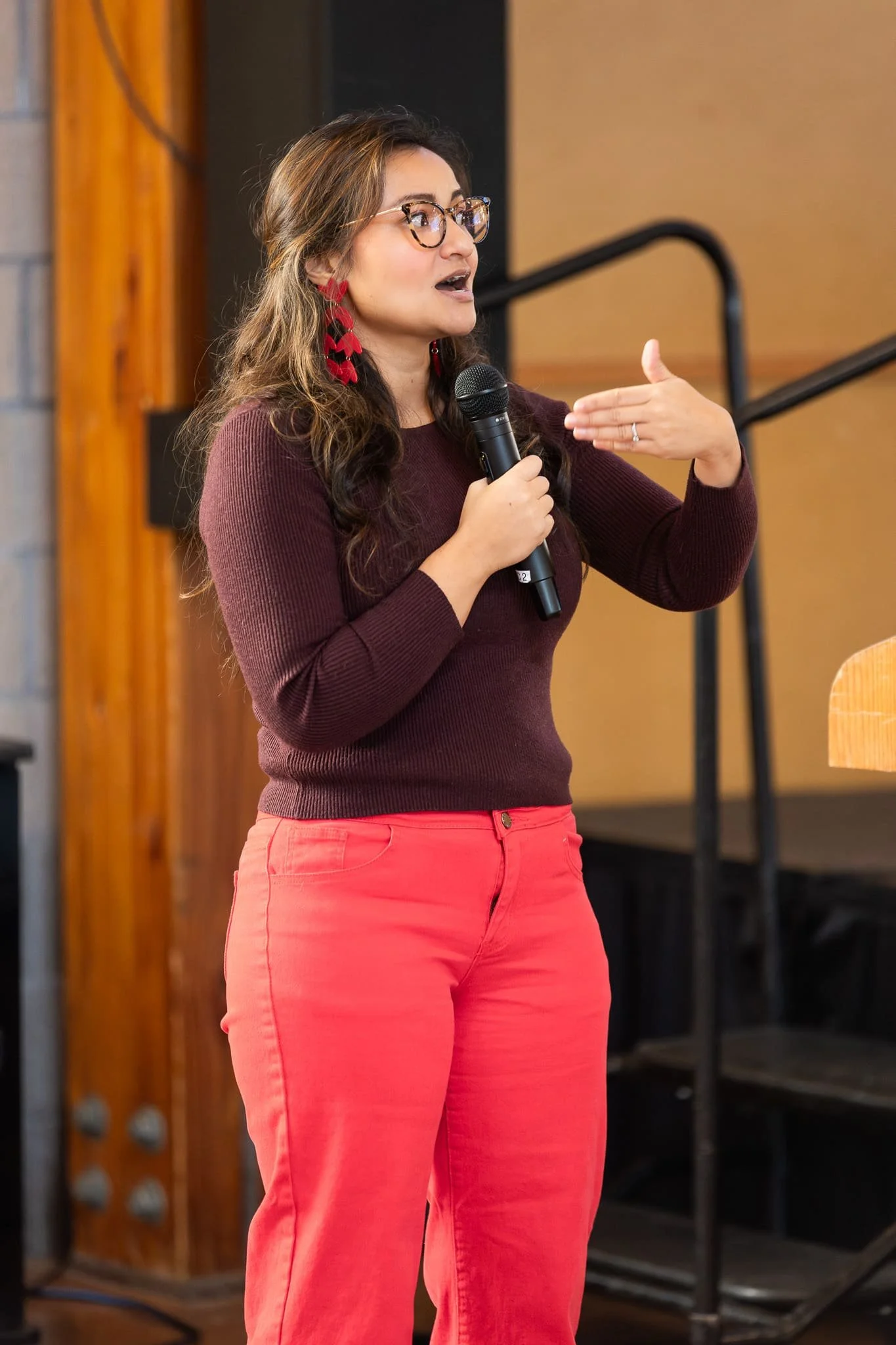 Alyssa W. Christensen speaking into a microphone during her real estate social media marketing presentation in Puyallup