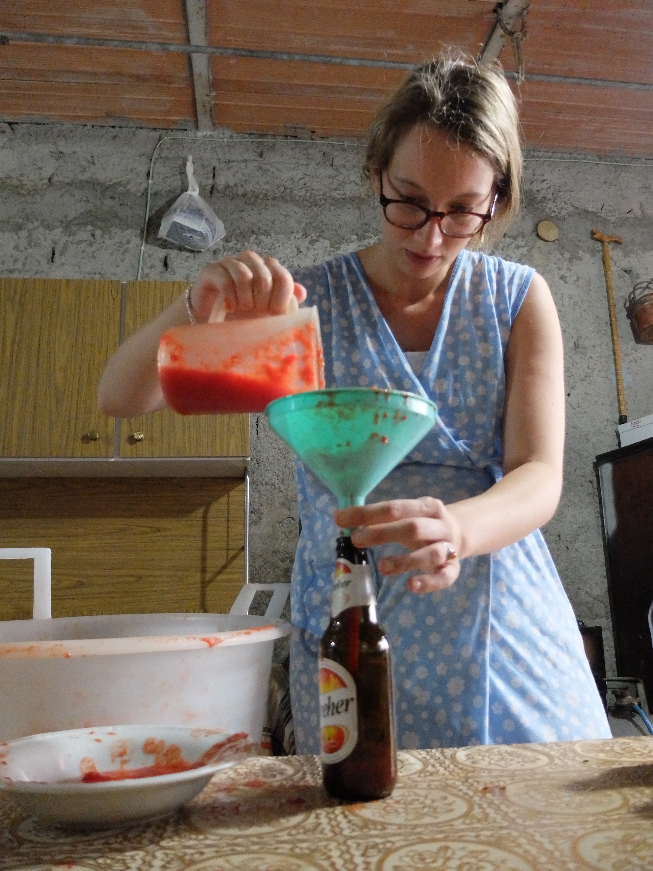 Simona filling up bottles with passata