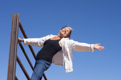 older-woman-outstretched-hands-on-climbing-frame
