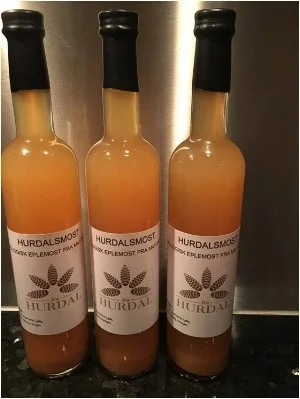 Logo: Hurdalsmost er produsert av epler fra en hage i Hurdal. Her med logoen til Hurdal Mat.