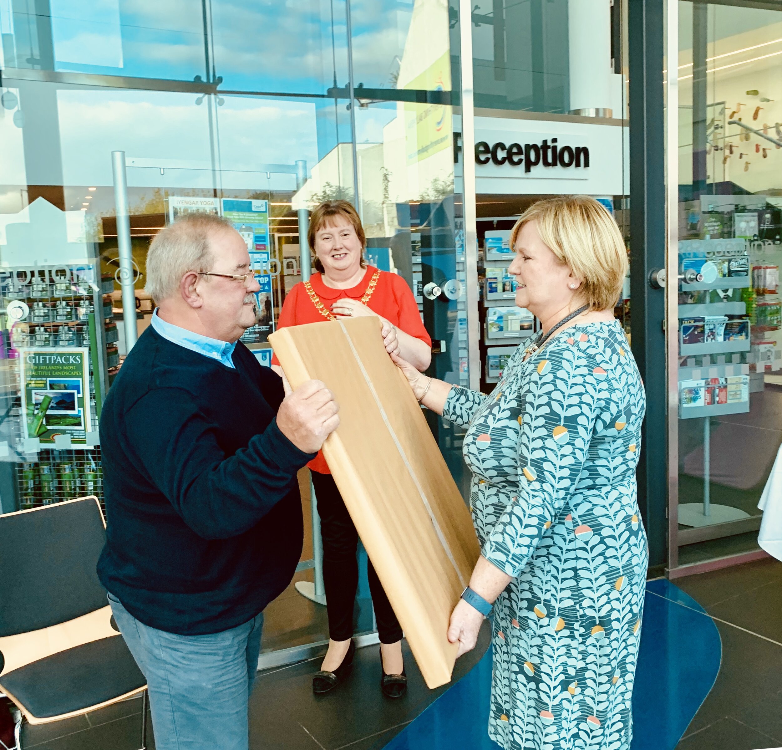 Theresa Patton presents a gift to founder Brian Holmes as the Mayor looks on.