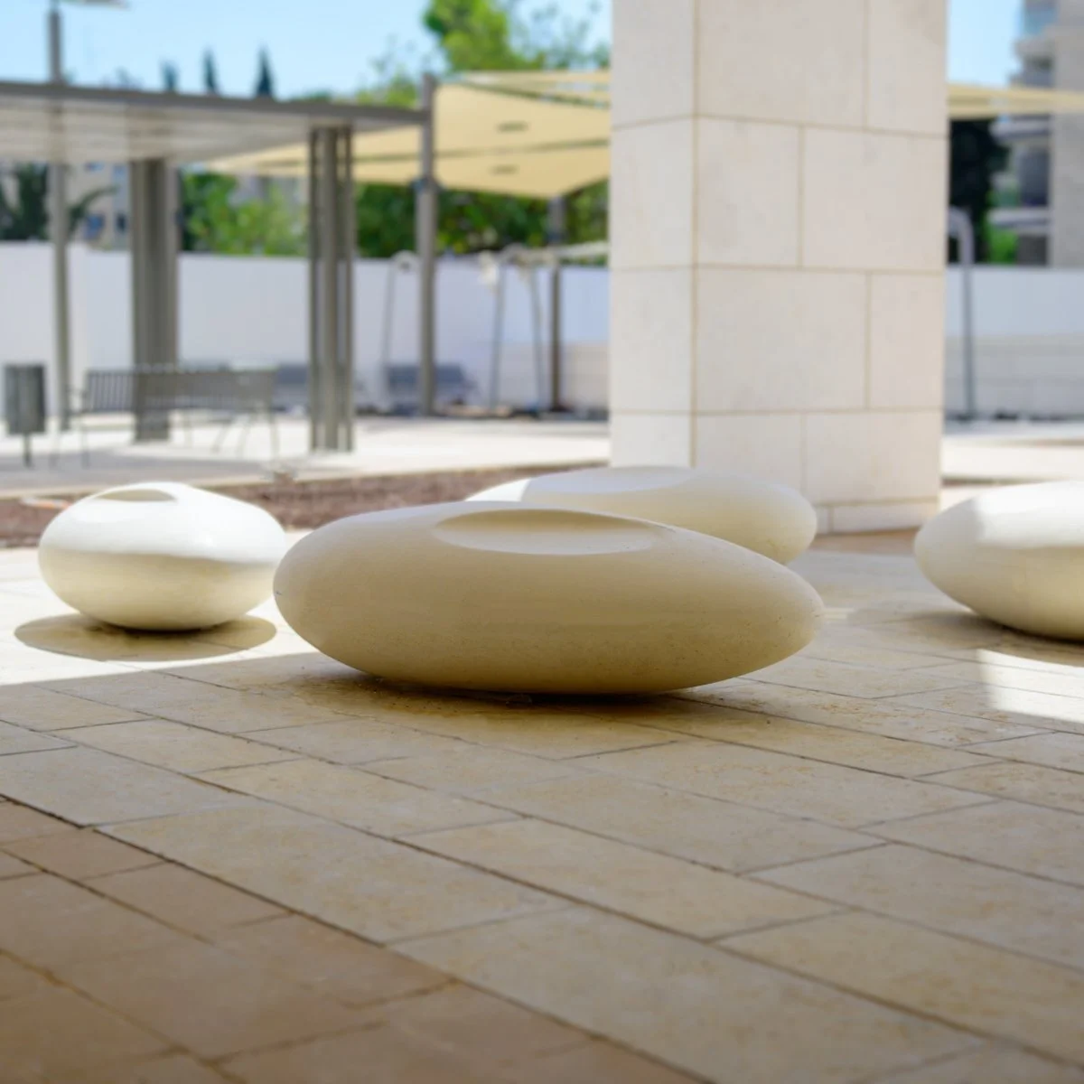 תקריב זרוע ספסל מתכת יצוקה עם לוגו LEMON, גימור מרקם גס בגוון אפור-ירקרק