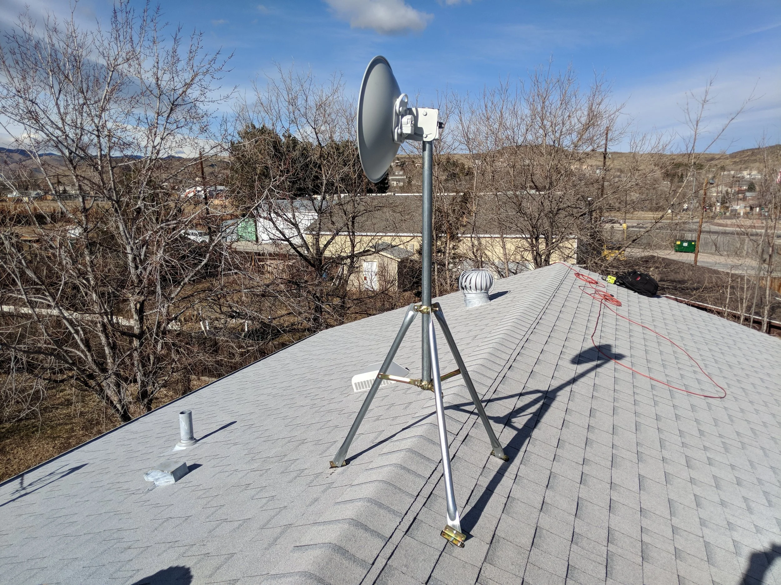 A dish radio mounted with a tri-pod. This was a liong distance shot that need the height to get above some trees.