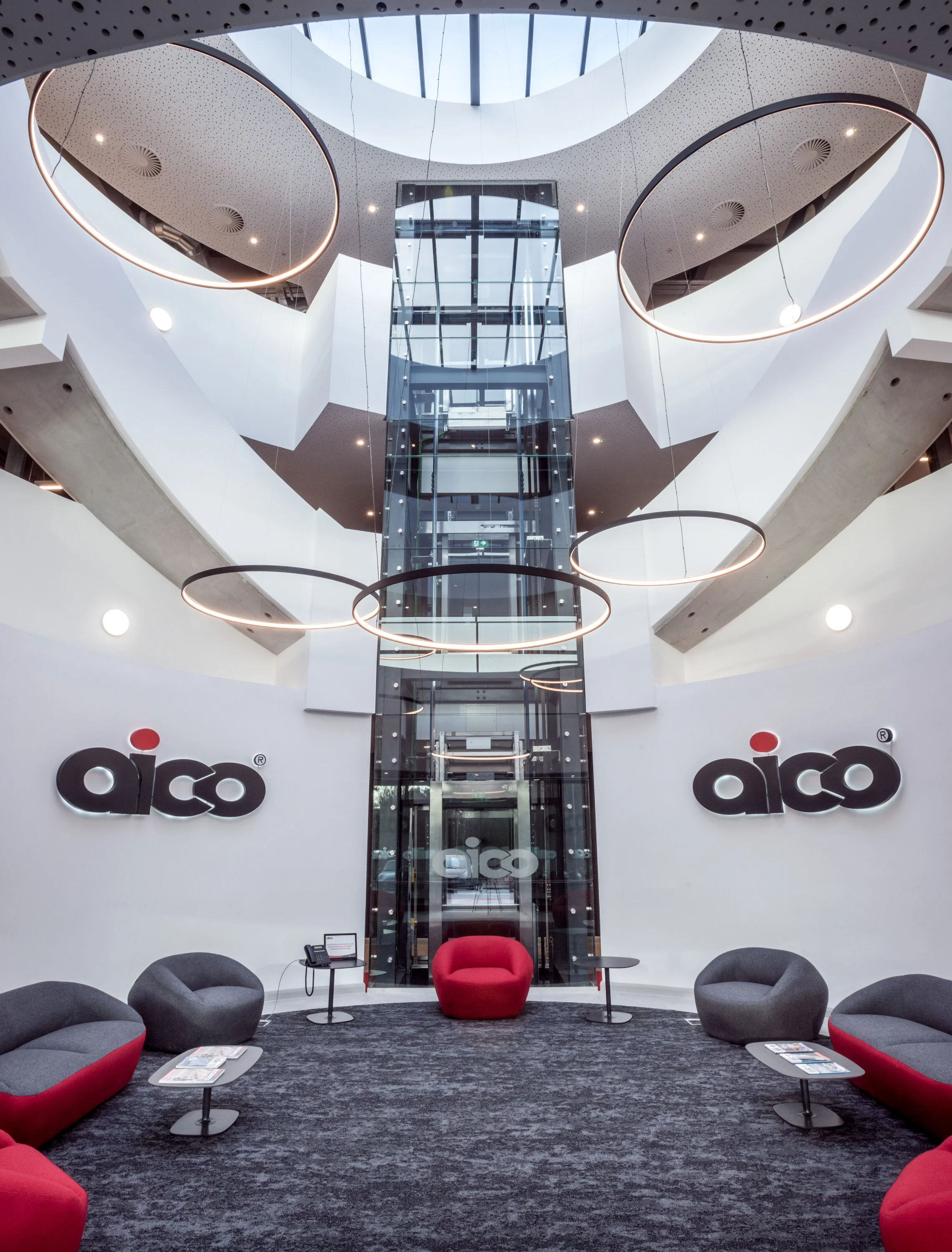 Architectural interior photography of Aico HQ lobby with chairs and spiral staircase surrounding the vestibule . Commercial property photography by Richard Stonehouse