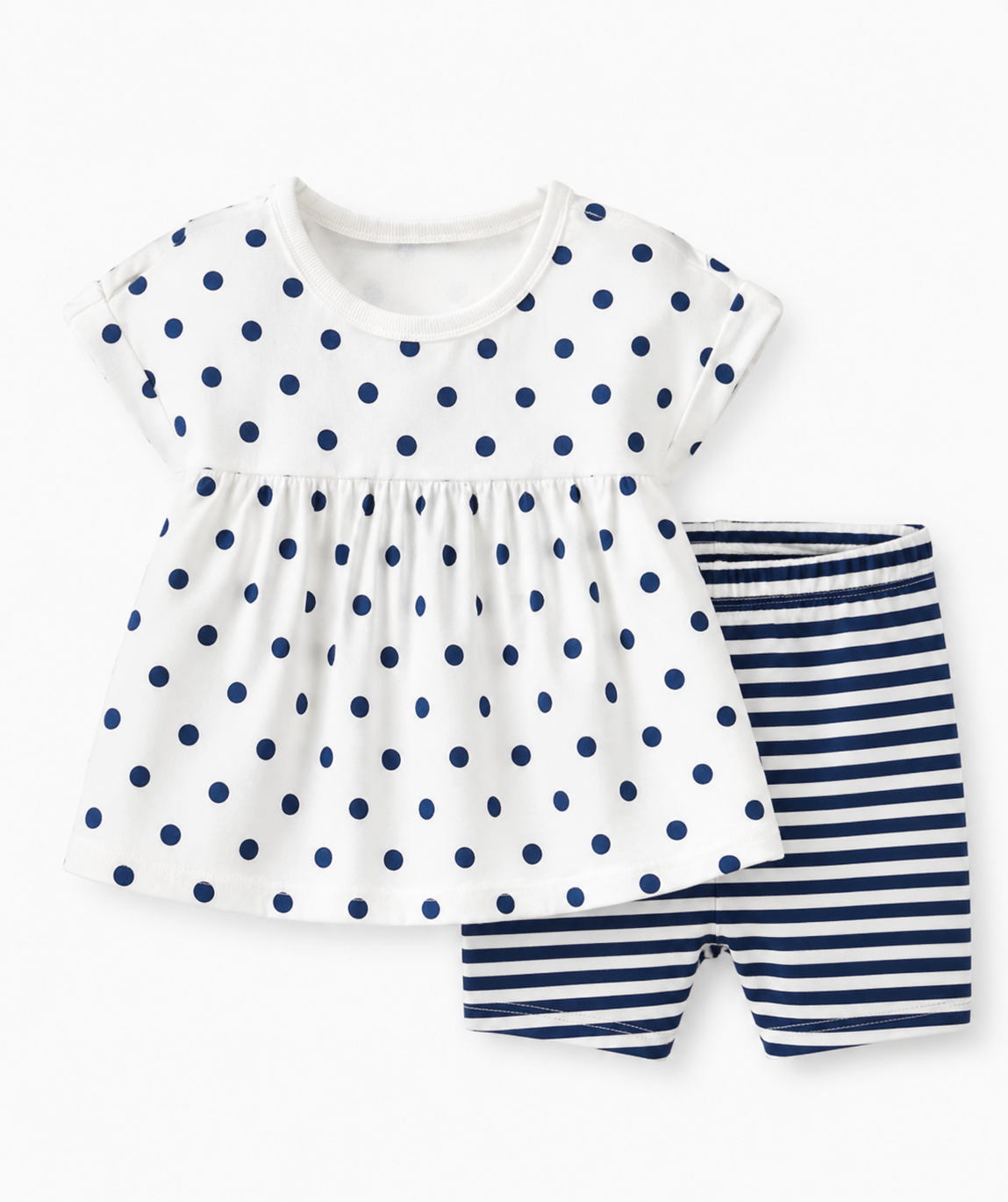 A white children's dress with navy polka dots and a gathers at the waist, paired with navy and white striped shorts. / E-Commerce Flat-Lay
