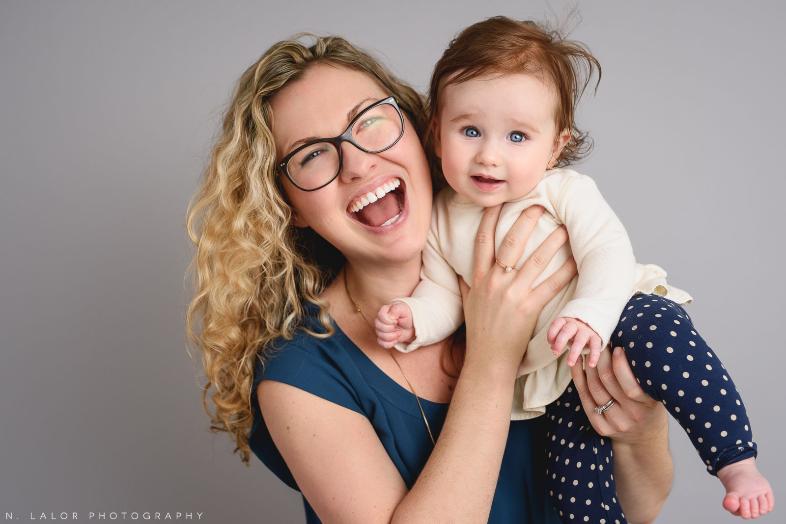 Mom with her baby girl, laughing. Family photo session by N. Lalor Photography. Studio located in Greenwich Connecticut.