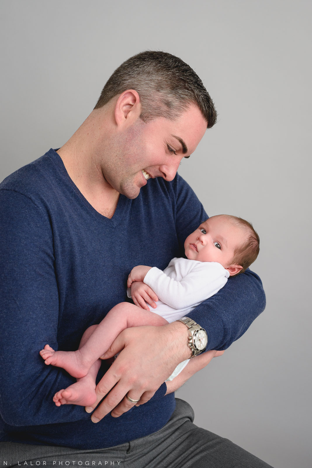 Sweet photo of son and dad. Newborn photo session by N. Lalor Photography. Greenwich, Connecticut.