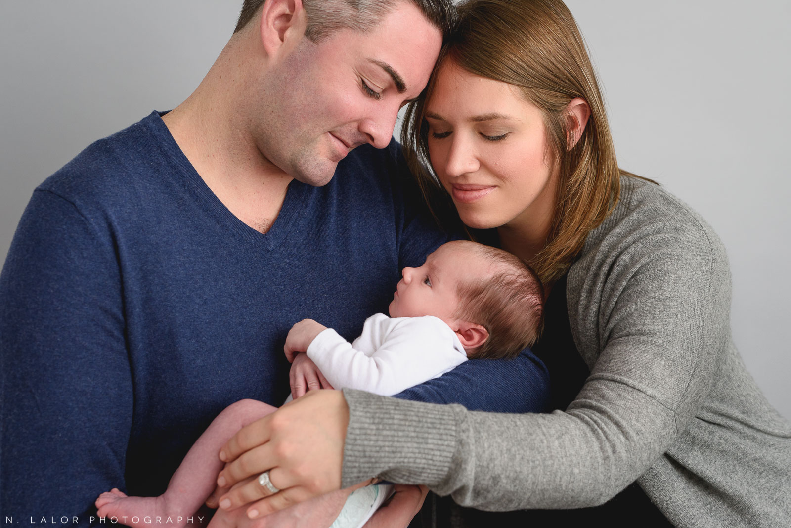 Parents together with their new baby boy. Newborn photo session by N. Lalor Photography. Greenwich, Connecticut.