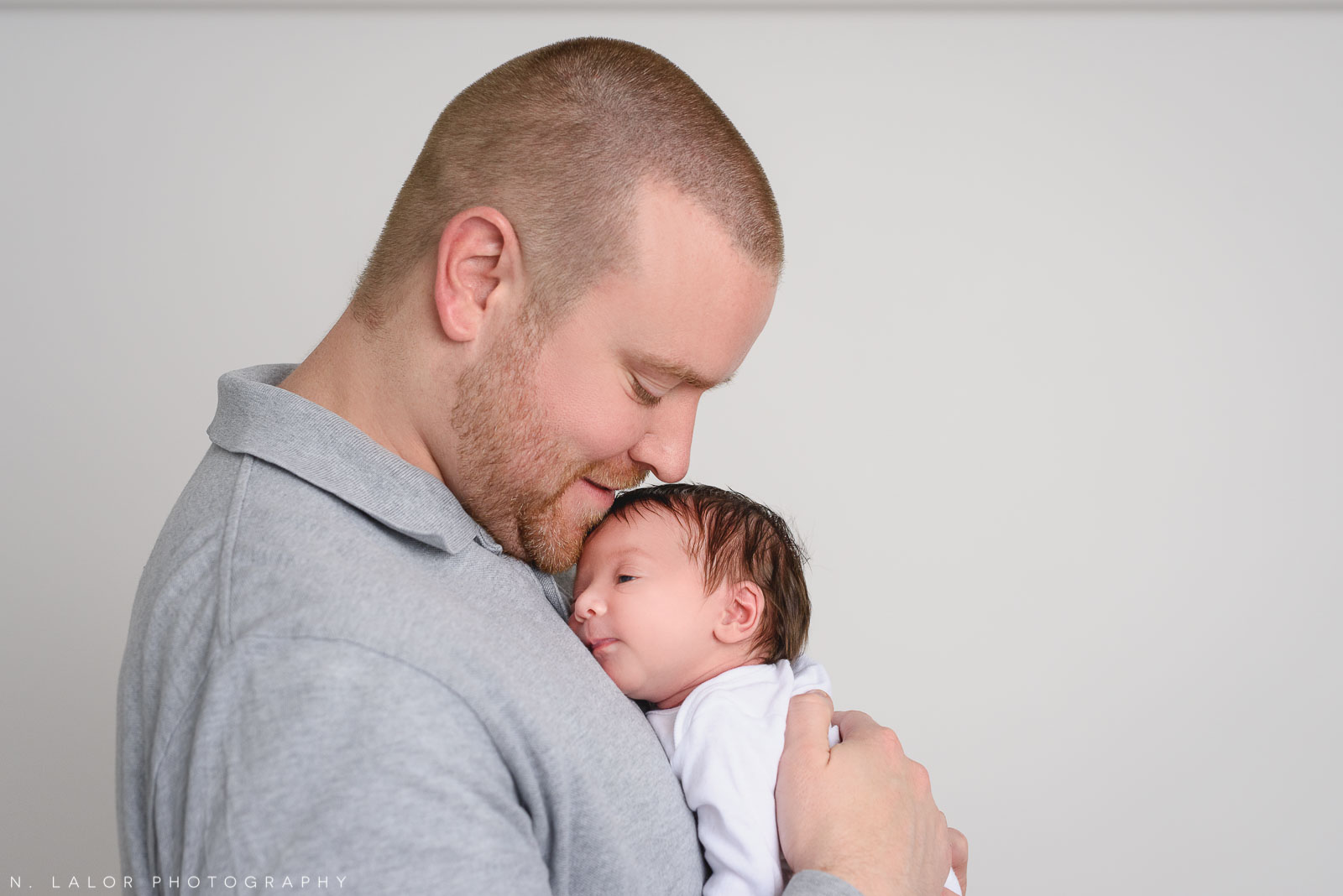 Sweet photo of dad with his newborn daughter. Newborn baby photo session with N. Lalor Photography. Studio located in Greenwich, Connecticut.