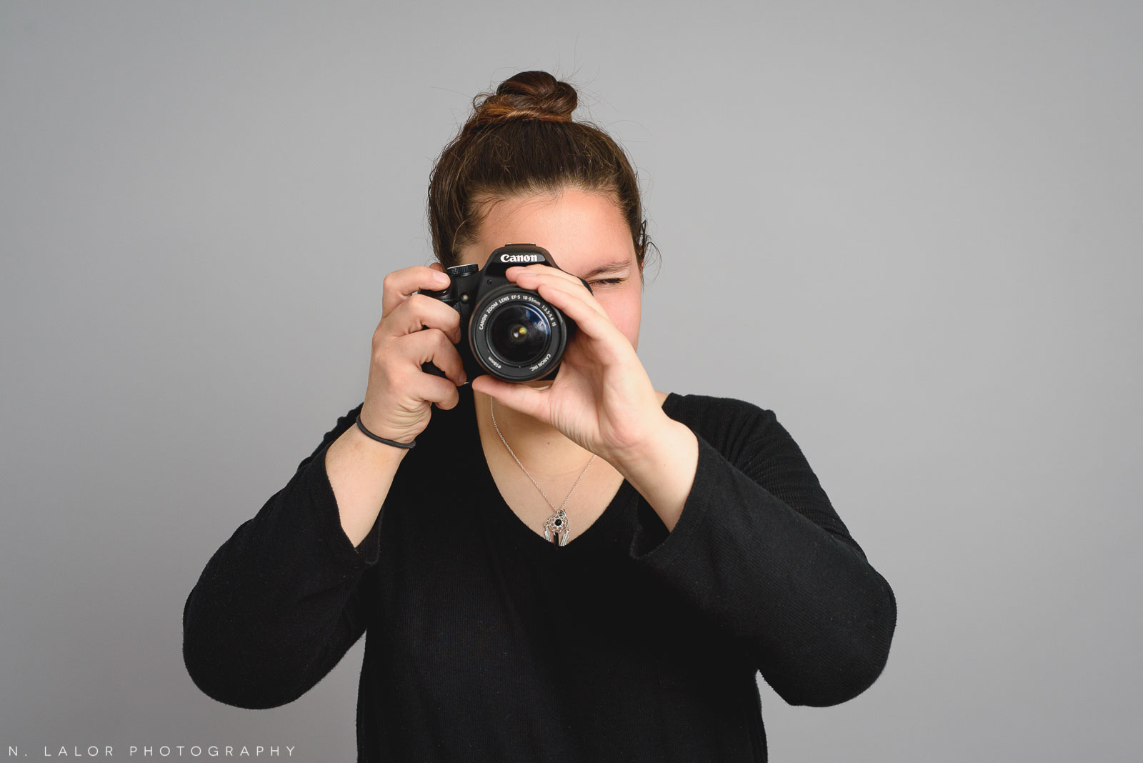 Sasha with her camera. Teen family photo session with N. Lalor Photography. Greenwich, Connecticut studio photographer.