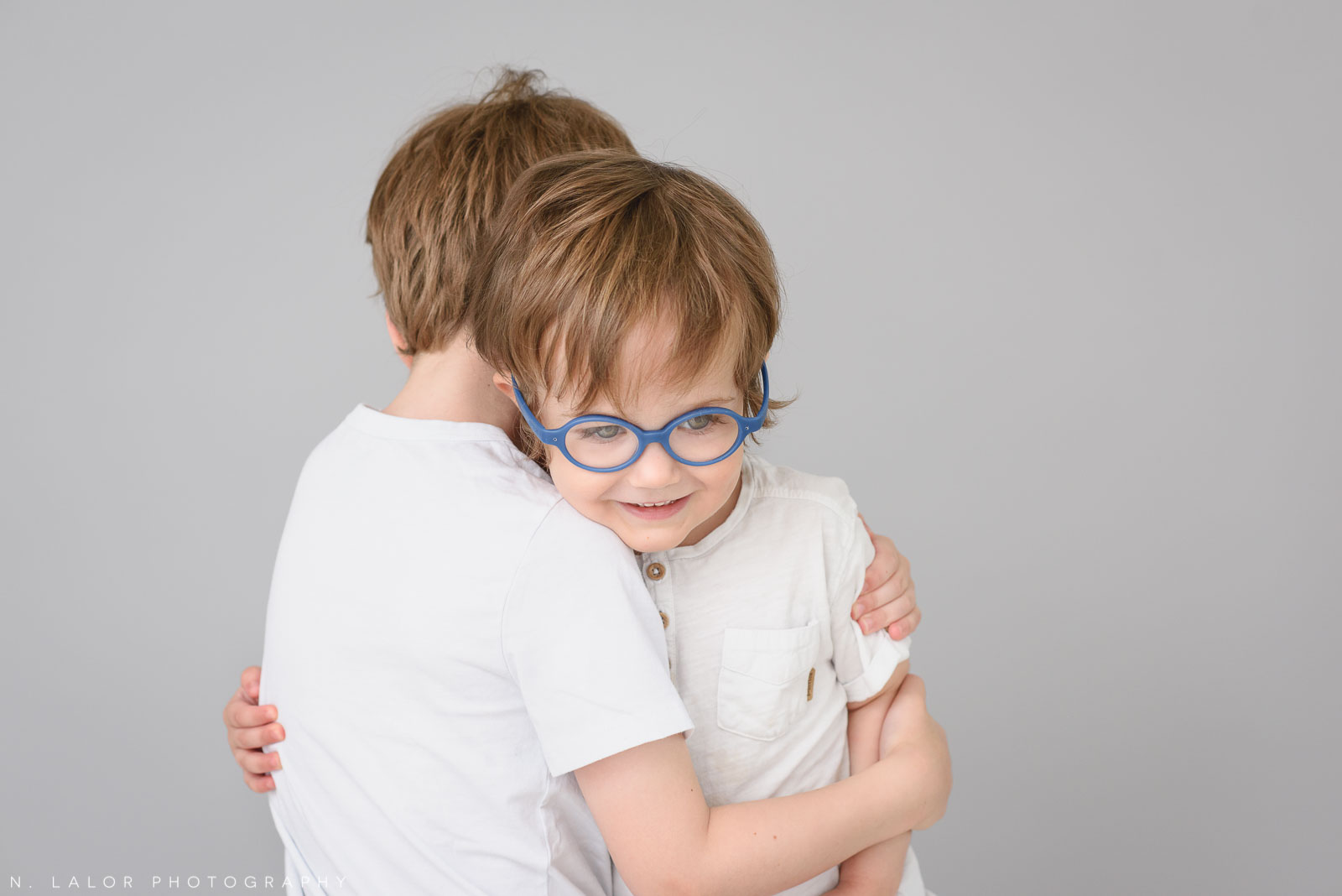 Brothers, a hug. Simple studio portrait session with N. Lalor Photography in Greenwich, CT.