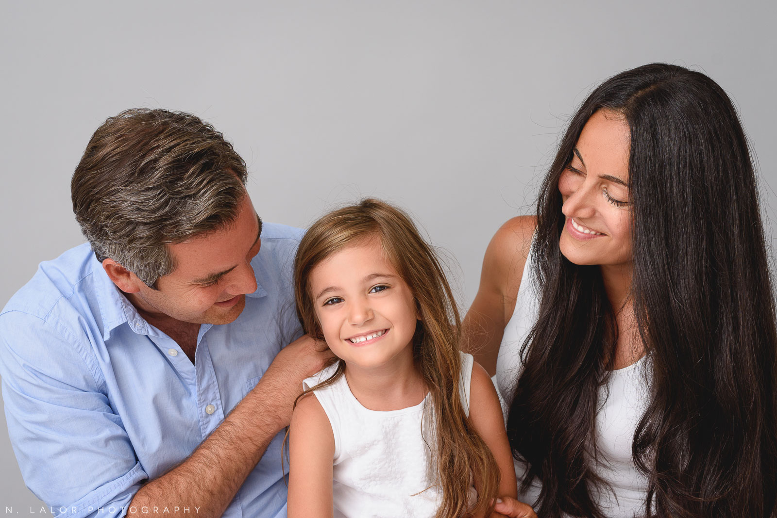 Young daughter with parents. Family photo session by N. Lalor Photography in Greenwich, CT.